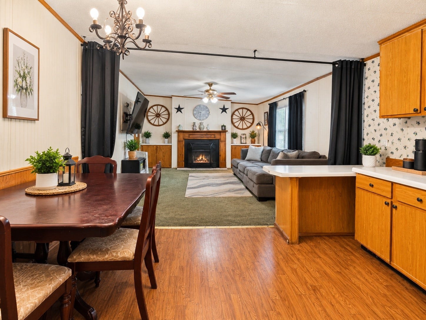 Virtually Edited  Dining & Living Area: Open-concept dining and living space featuring a fireplace, ceiling fans, and convenient flow into the kitchen.