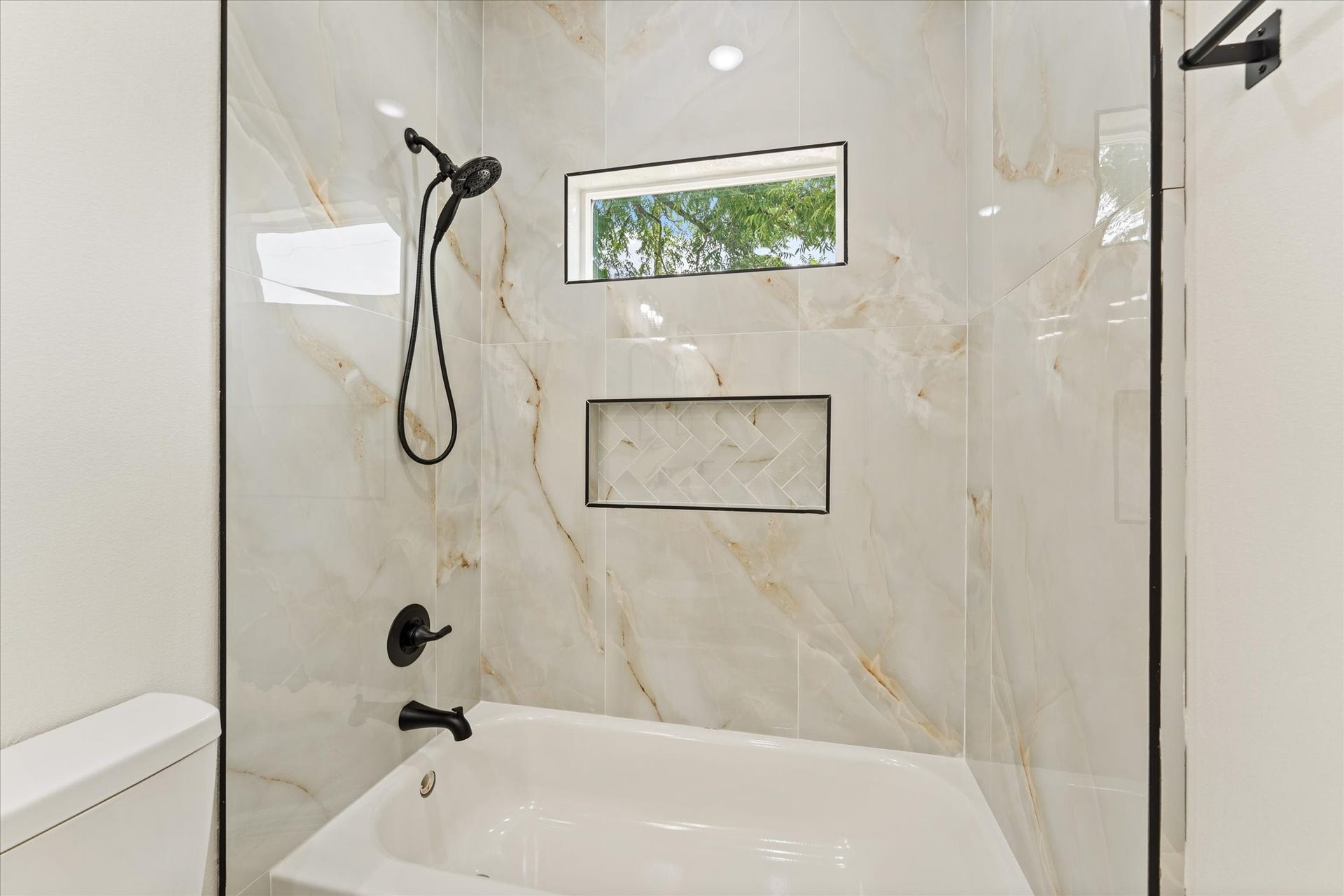 9119 Henrietta Street, #A/B, Houston, TX 77088 Floor to ceiling designer tile, a built in niche, and sleek matte black fixtures create a
sophisticated bathing space.