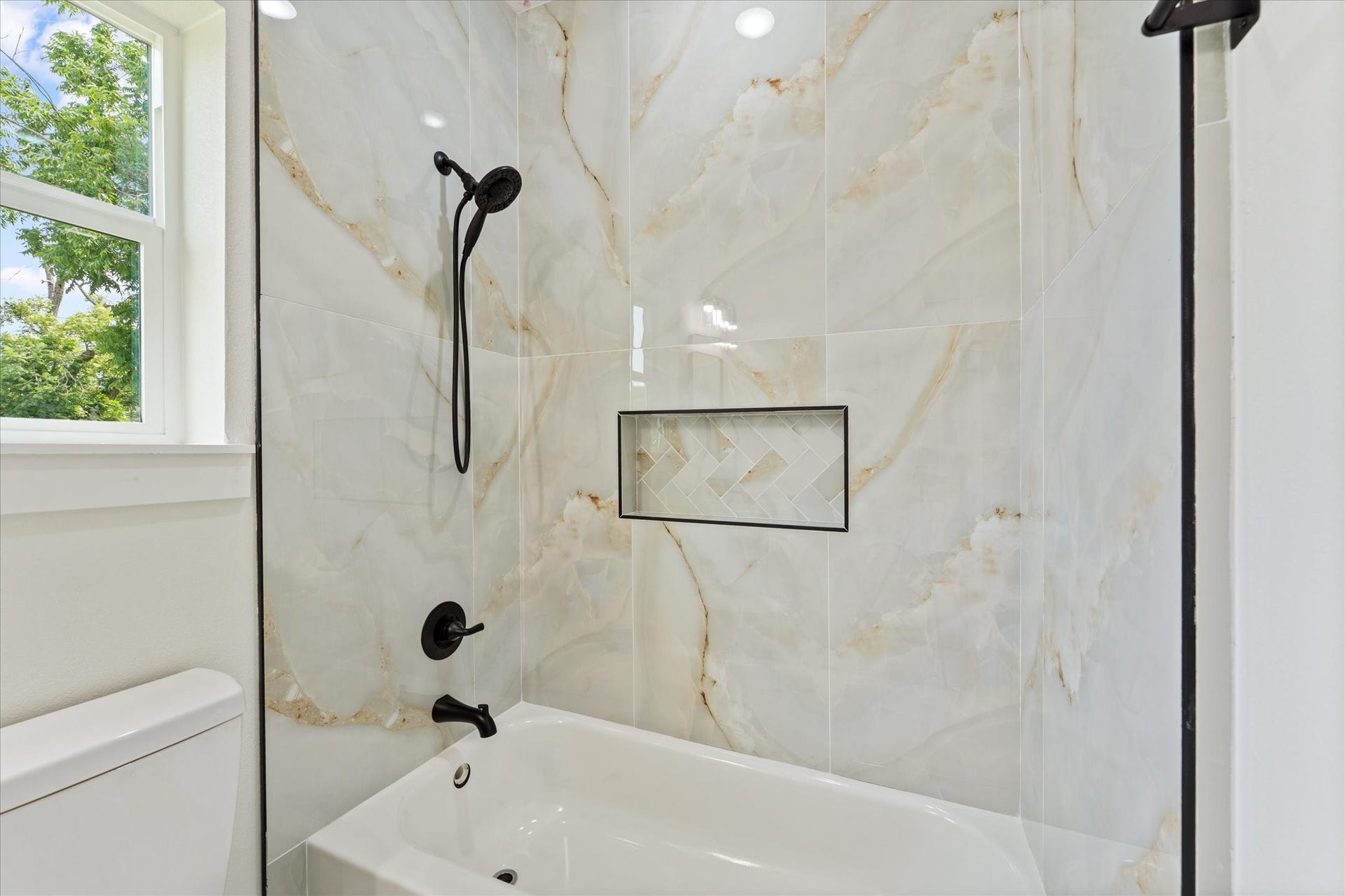 9119 Henrietta Street, #A/B, Houston, TX 77088 A beautifully tiled tub surround with decorative niches and a transom window adds both
function and designer appeal.