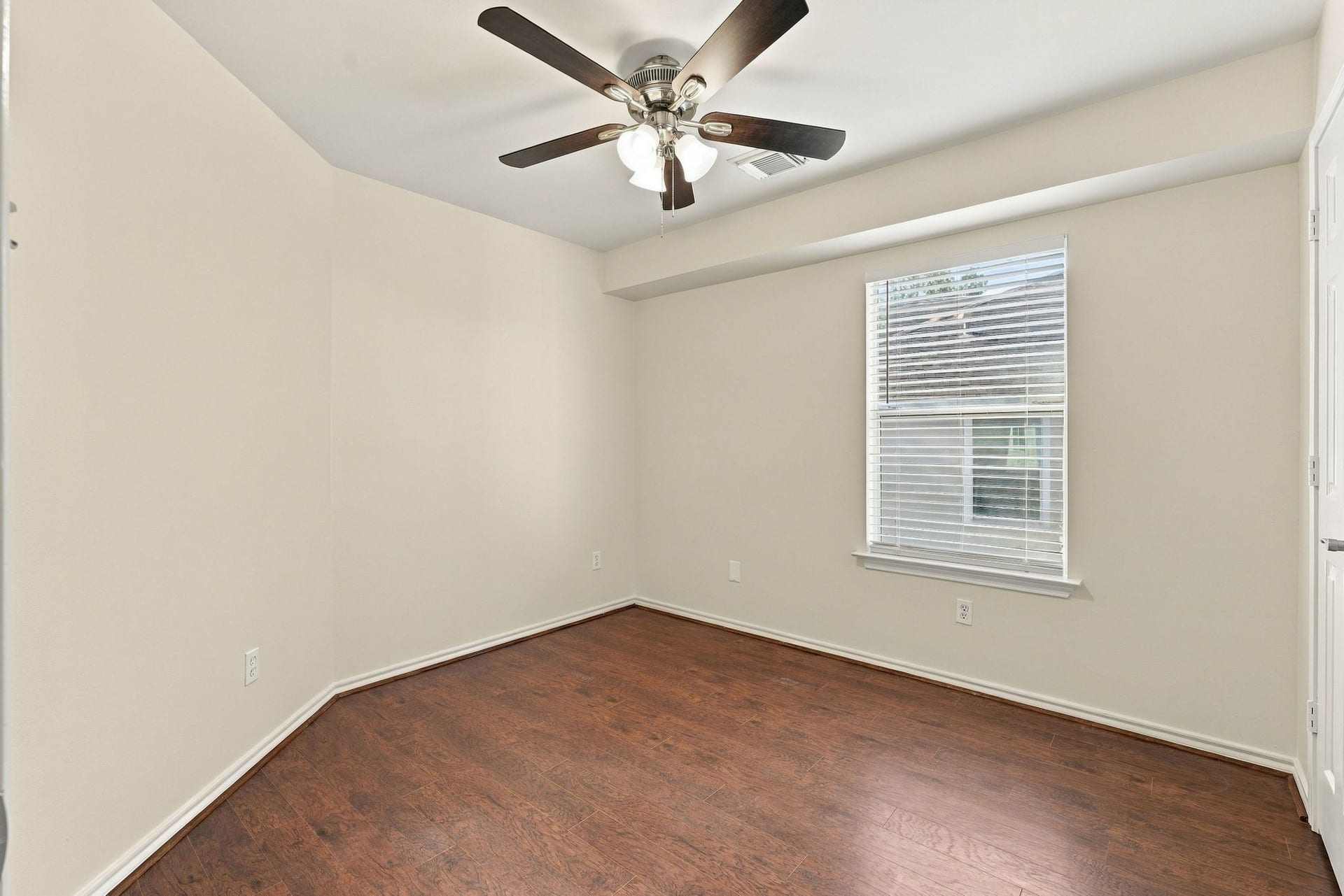 142 N Camellia Grove Circle, The Woodlands, TX 77382 Bedroom number 2 has the wood look flooring, new paint and new ceiling fan.