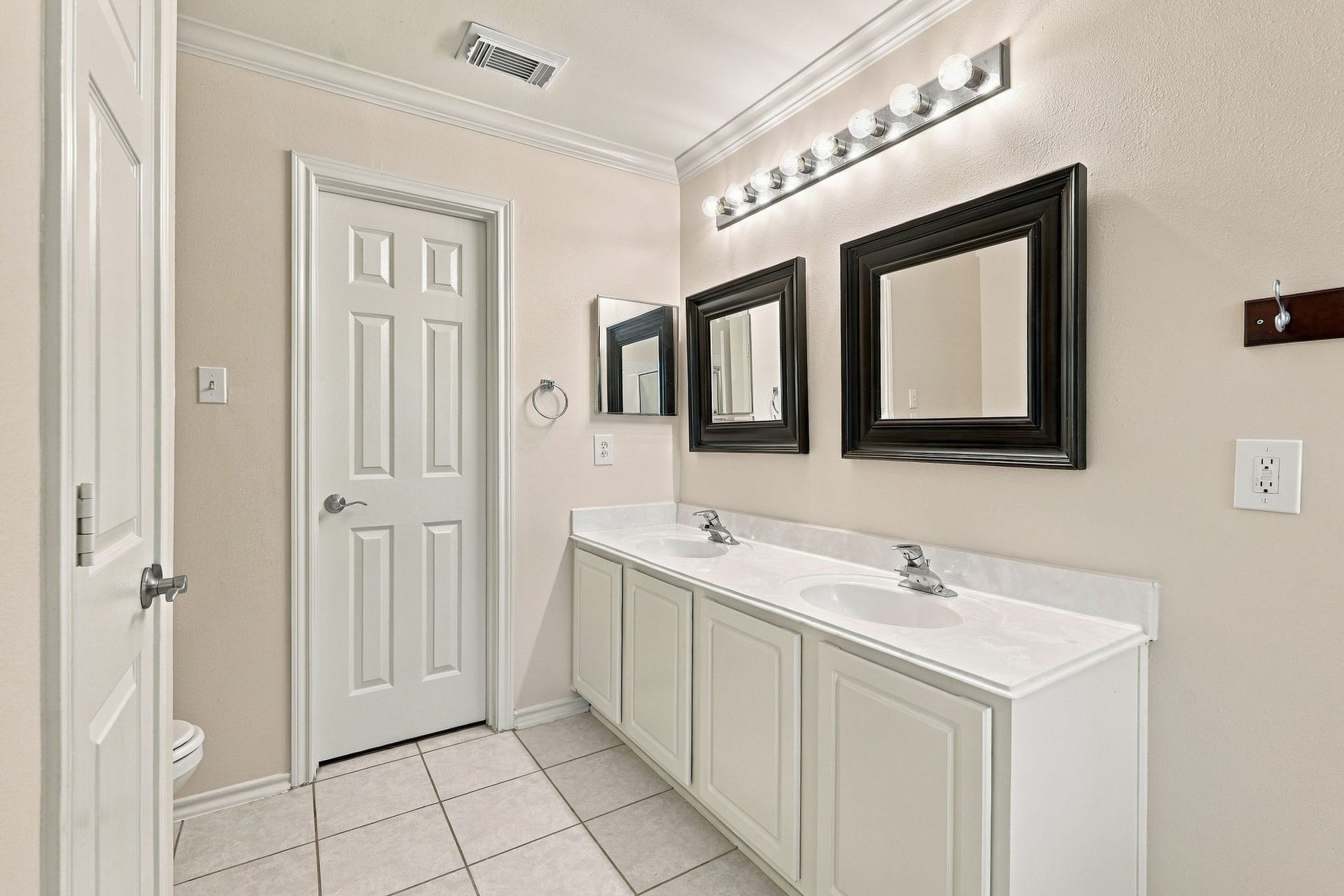 142 N Camellia Grove Circle, The Woodlands, TX 77382 The primary bathroom offers dual sinks, trendy mirrors, and a large walk in closet (behind this door)
