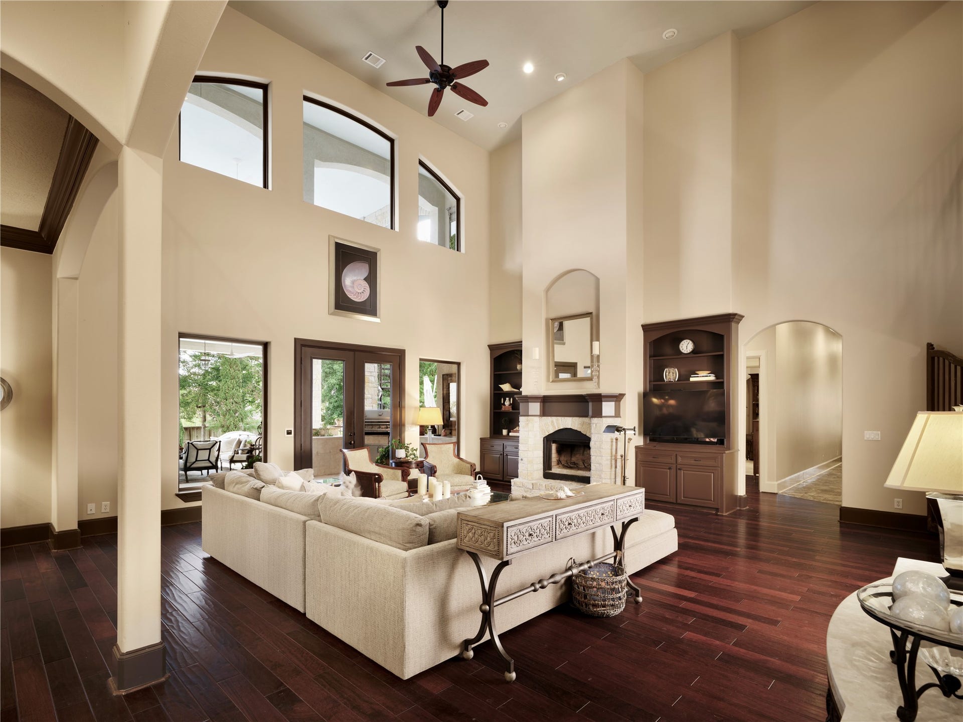 6702 Star Ledge Court, Spring, TX 77389 GREAT ROOM 2 Anchored by a striking limestone fireplace with custom built-in cabinetry, the Great Room offers a warm and inviting setting for both everyday living and elegant entertaining. Towering ceilings and expansive windows fill the space with natural light while framing views of the covered outdoor living areas and beautifully landscaped grounds. Seamlessly connected to the kitchen, the room creates an effortless flow for gathering with family and friends, balancing impressive scale.
