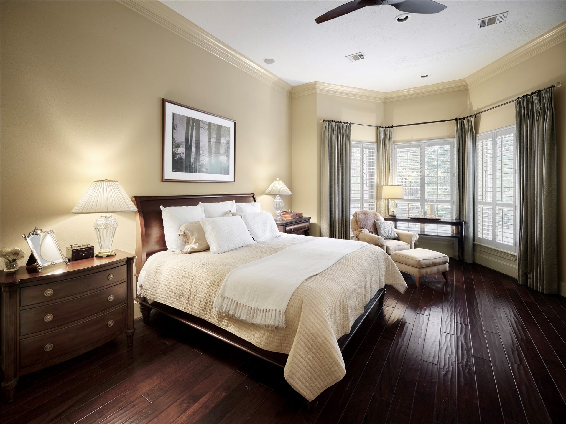6702 Star Ledge Court, Spring, TX 77389 PrRIMARY SUITE Serene retreat designed for comfort and quiet luxury, the spacious primary suite features rich hardwood floors, soaring ceilings, and a wall of windows framing picturesque views of the beautifully landscaped backyard. A gracious sitting area invites peaceful mornings with coffee or quiet evenings overlooking the private grounds. Custom built-in bookshelves and a writing desk provide an ideal space for reading, working, or reflection. Generous in scale and timeless in design, the suite offe