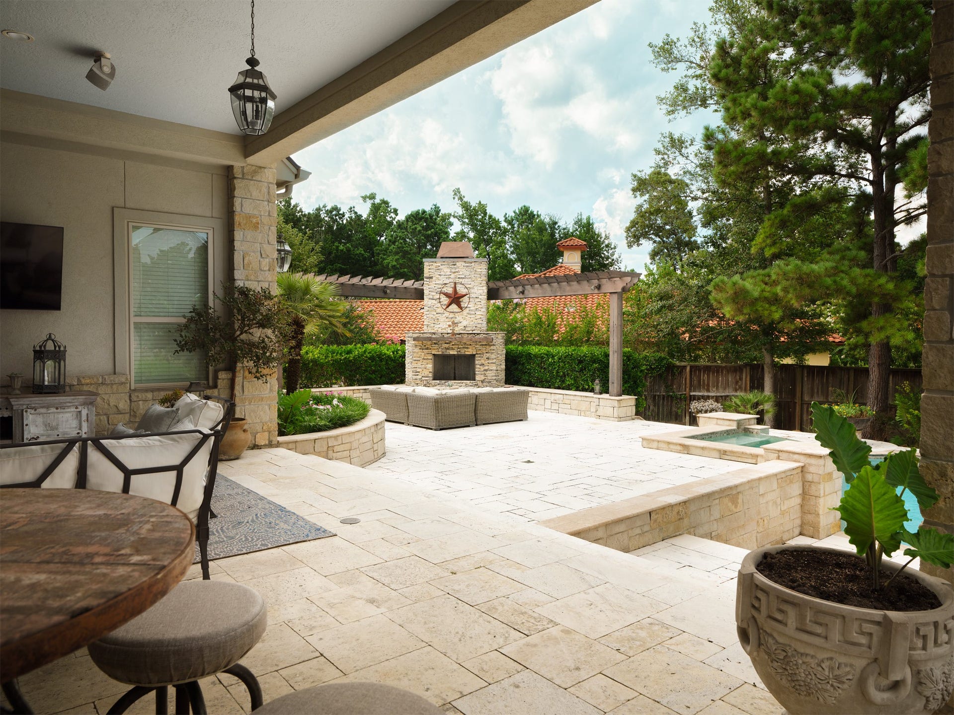 6702 Star Ledge Court, Spring, TX 77389 OUTDOOR Terrace Beyond the covered pavilion, expansive limestone terraces lead to a striking outdoor fireplace framed by a pergola, creating a distinctive destination for evening conversation and year-round enjoyment. Layered gathering spaces, elegant hardscaping, and the custom pool are seamlessly integrated into the landscape, offering exceptional flexibility for entertaining, relaxing, or enjoying the privacy of the estate. Every element has been carefully composed to create outdoor fun.