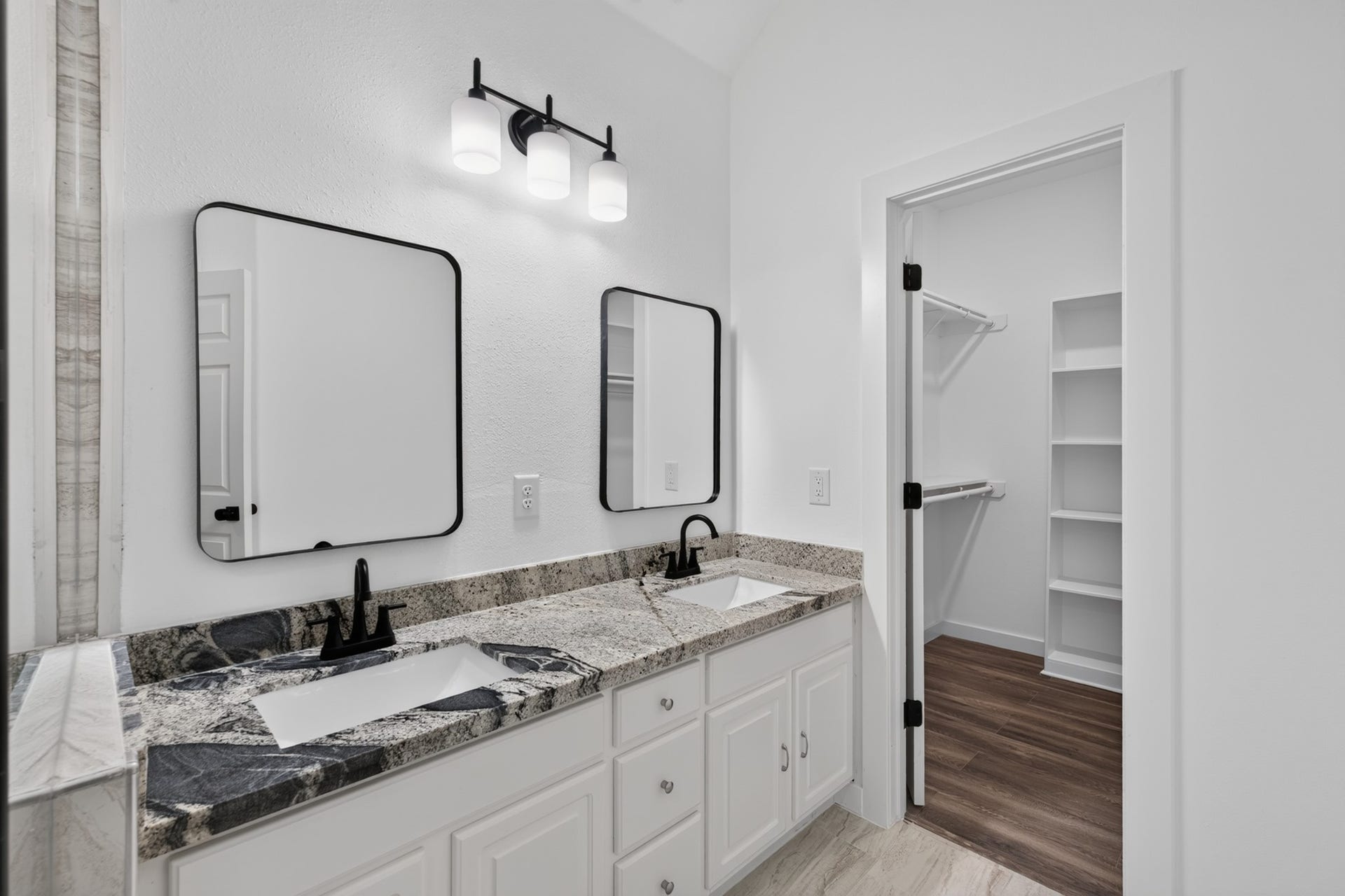 18 Griffin Hill Court, The Woodlands, TX 77382 The primary bathroom at 18 Griffin Hill Court is appointed with a stunning double-sink vanity, framed mirrors, stylish modern fixtures, and beautiful tile flooring. Thoughtfully designed with ample counter space and excellent storage, this bathroom provides the comfort and functionality of a luxury retreat right within the privacy of your own home.