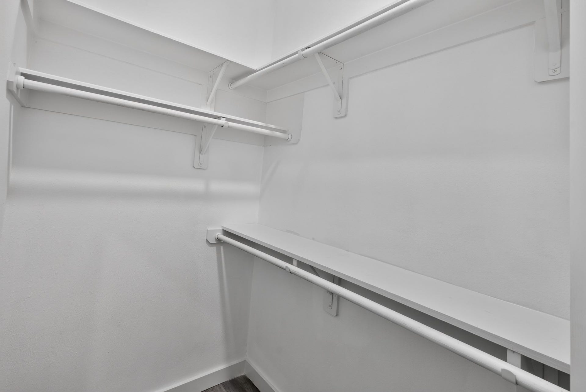 18 Griffin Hill Court, The Woodlands, TX 77382 Another view of the impressive walk-in closet at 18 Griffin Hill Court showcases the full extent of its built-in organization system, including multiple hanging rods and open shelving sections. Whether for shoes, seasonal wardrobe, or everyday essentials, this closet provides a beautifully functional and generously sized personal storage solution.