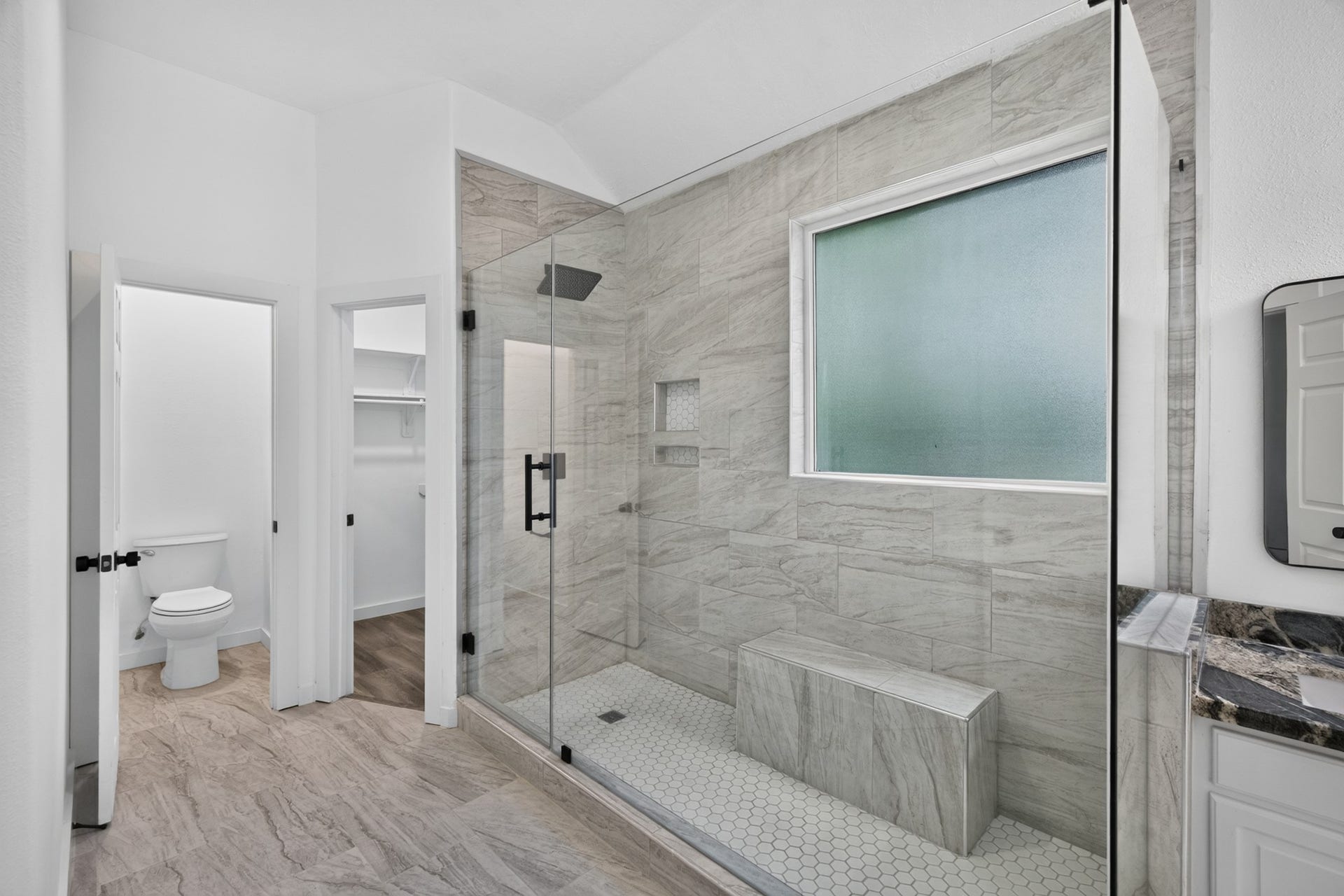 18 Griffin Hill Court, The Woodlands, TX 77382 The spa-inspired bathroom at 18 Griffin Hill Court features beautiful floor-to-ceiling tile work, a spacious walk-in shower with glass enclosure, and a clean modern aesthetic. Every detail has been carefully selected to create a tranquil retreat where you can relax and recharge a true escape from the demands of everyday life.