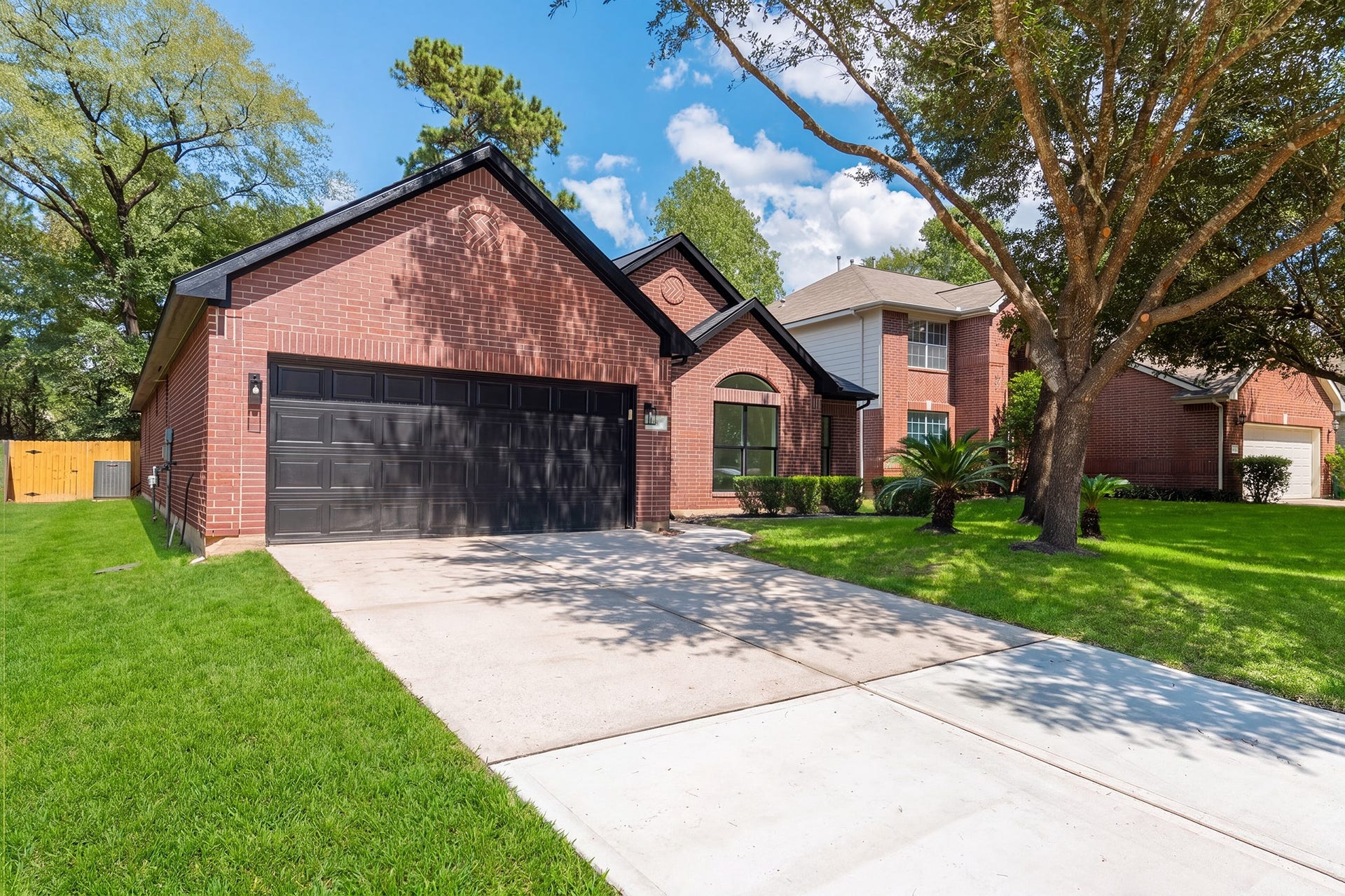 18 Griffin Hill Court, The Woodlands, TX 77382 Daytime curb appeal at its finest 18 Griffin Hill Court shines under a bright blue Texas sky. This beautifully maintained single-story brick home features lush green landscaping, a magnificent mature oak tree in the front yard, and a spacious two-car garage, creating outstanding first impressions in this desirable Spring neighborhood.