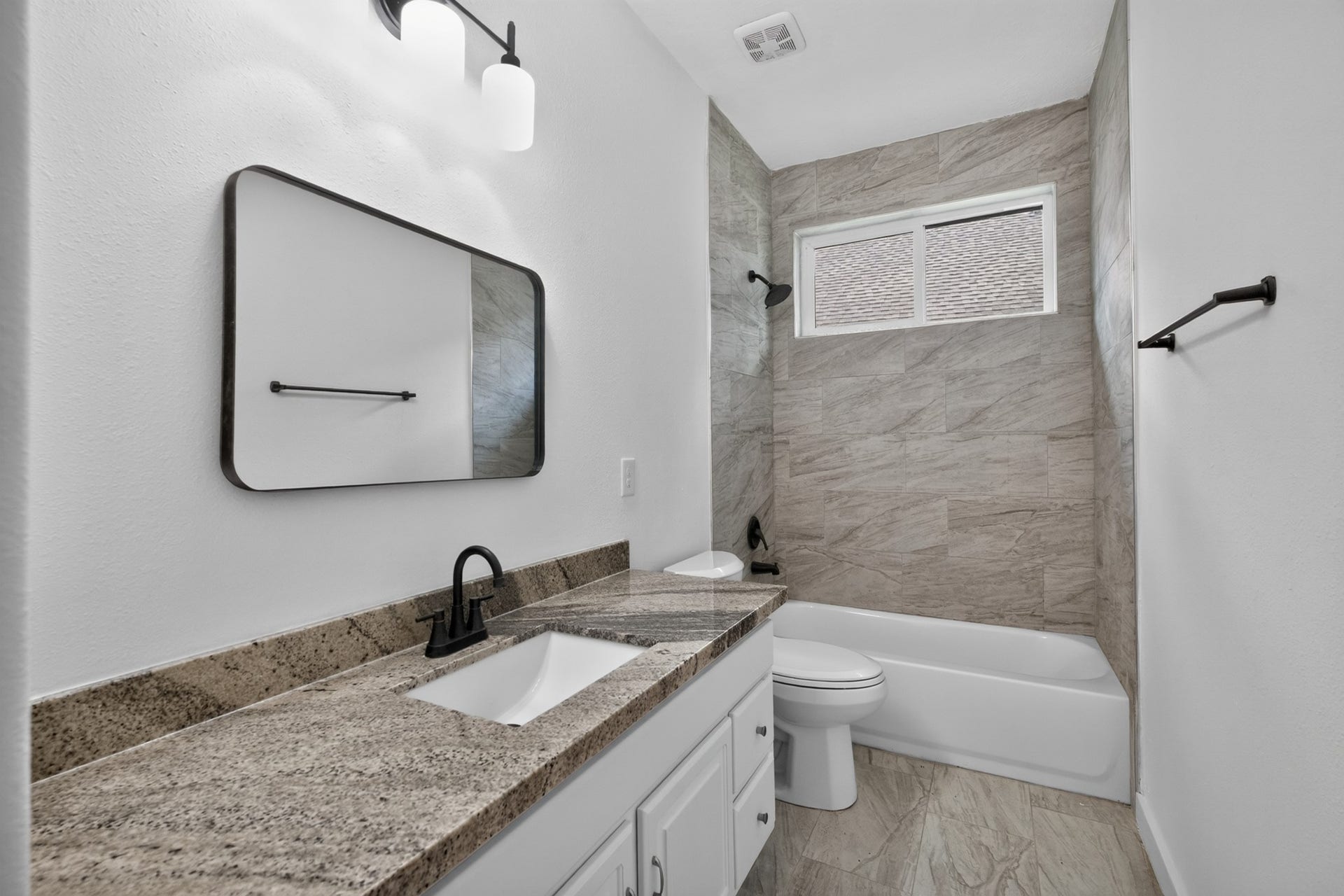 18 Griffin Hill Court, The Woodlands, TX 77382 A beautifully appointed secondary bathroom at 18 Griffin Hill Court features rich tile walls, a modern vanity with sink, an oversized mirror, and quality fixtures throughout. Clean, contemporary, and thoughtfully designed, this bathroom provides both the everyday functionality and the polished aesthetic appeal that today's discerning homebuyer expects.