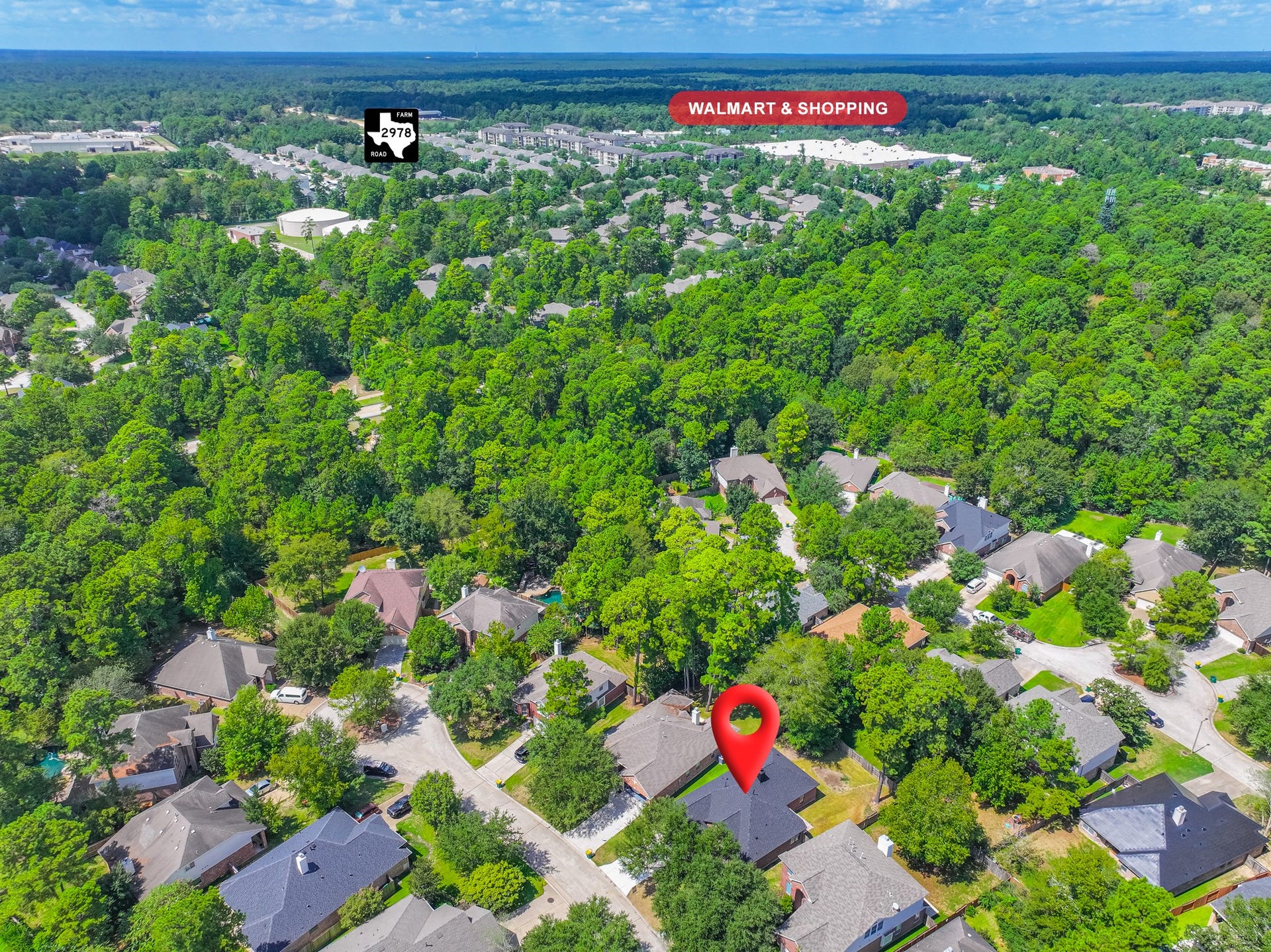 18 Griffin Hill Court, The Woodlands, TX 77382 Higher aerial perspective showcasing 18 Griffin Hill Court and its surrounding community. The established neighborhood features mature tree canopies, well-maintained homes, and a peaceful residential setting. This bird's-eye view captures the wonderful sense of community and easy access to the Spring, Texas area's many sought-after amenities.