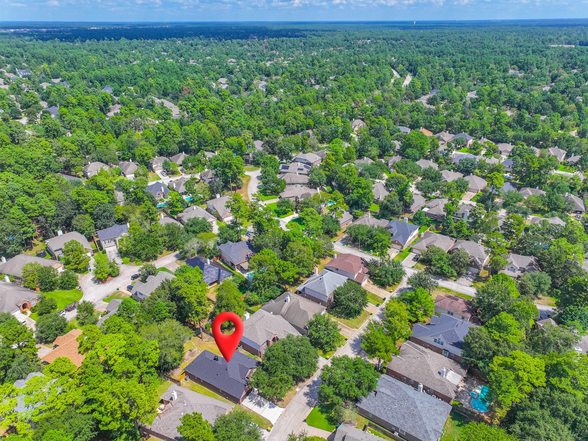 18 Griffin Hill Court, The Woodlands, TX 77382 Aerial view highlighting the prime location of 18 Griffin Hill Court within its lushly canopied neighborhood. Towering mature trees create a stunning green landscape throughout this established community, offering privacy, shade, and the serene residential atmosphere that makes this Spring, Texas neighborhood so desirable to call home.