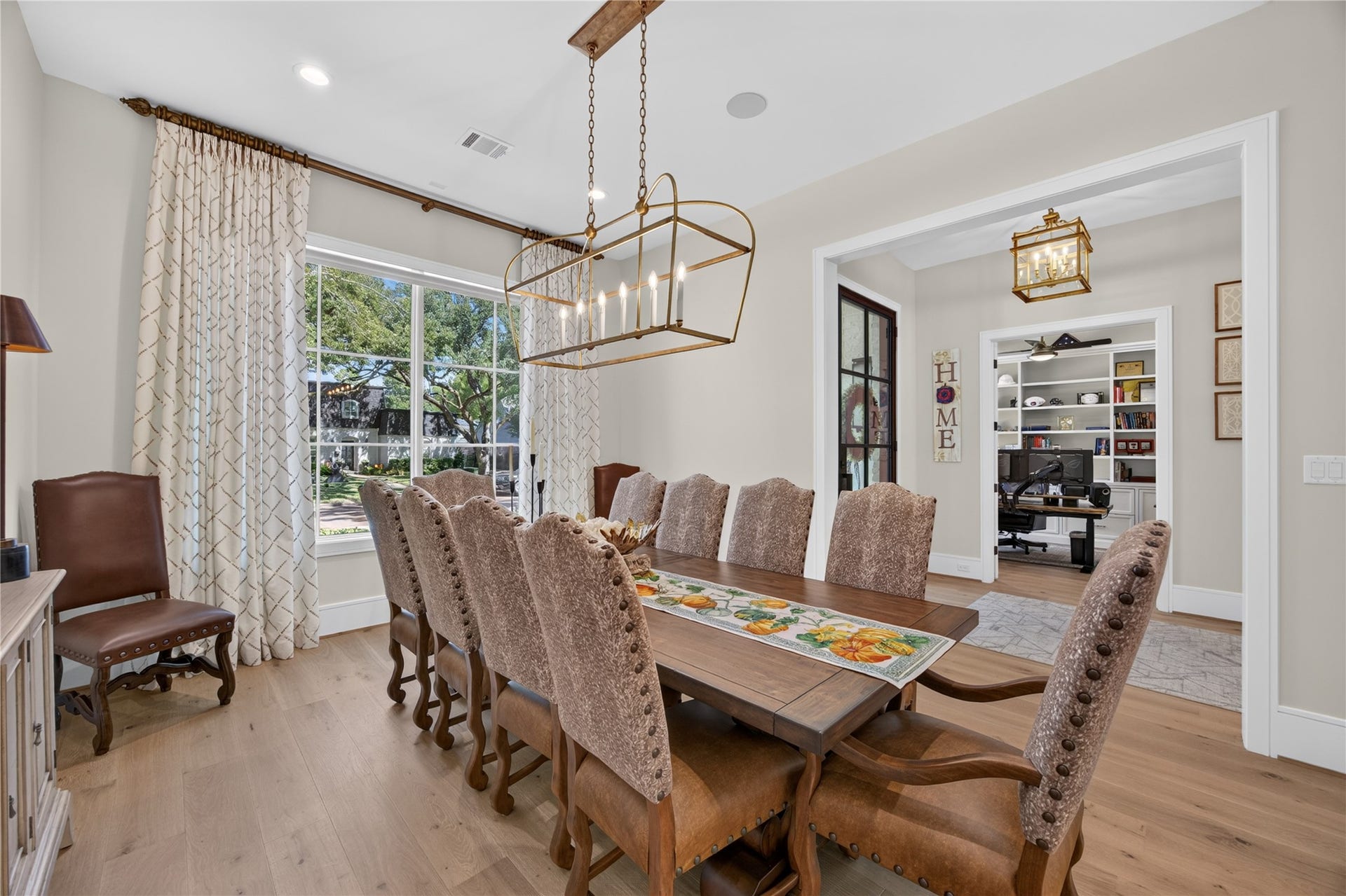 13915 Queensbury Lane, Houston, TX 77079 Beautifully appointed formal dining room featuring a statement gold chandelier, wide-plank wood flooring, and an oversized window that fills the space with natural light. Generous proportions provide an elegant setting for hosting dinner parties, holiday gatherings, and everyday dining.