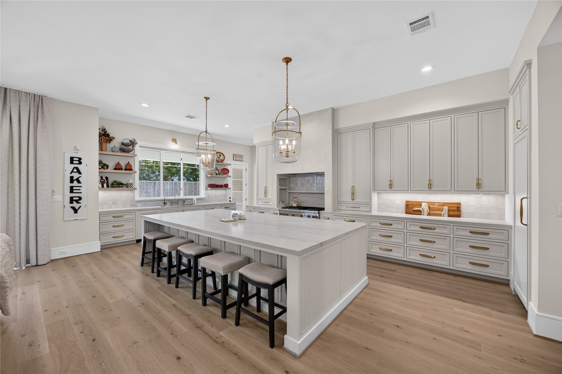 13915 Queensbury Lane, Houston, TX 77079 A beautifully designed kitchen featuring an oversized 13ft island with seating for five, elegant quartzite countertops, custom cabinetry with gold hardware, and statement pendant lighting. Abundant counter space and thoughtful storage make this kitchen ideal for everyday living and entertaining.