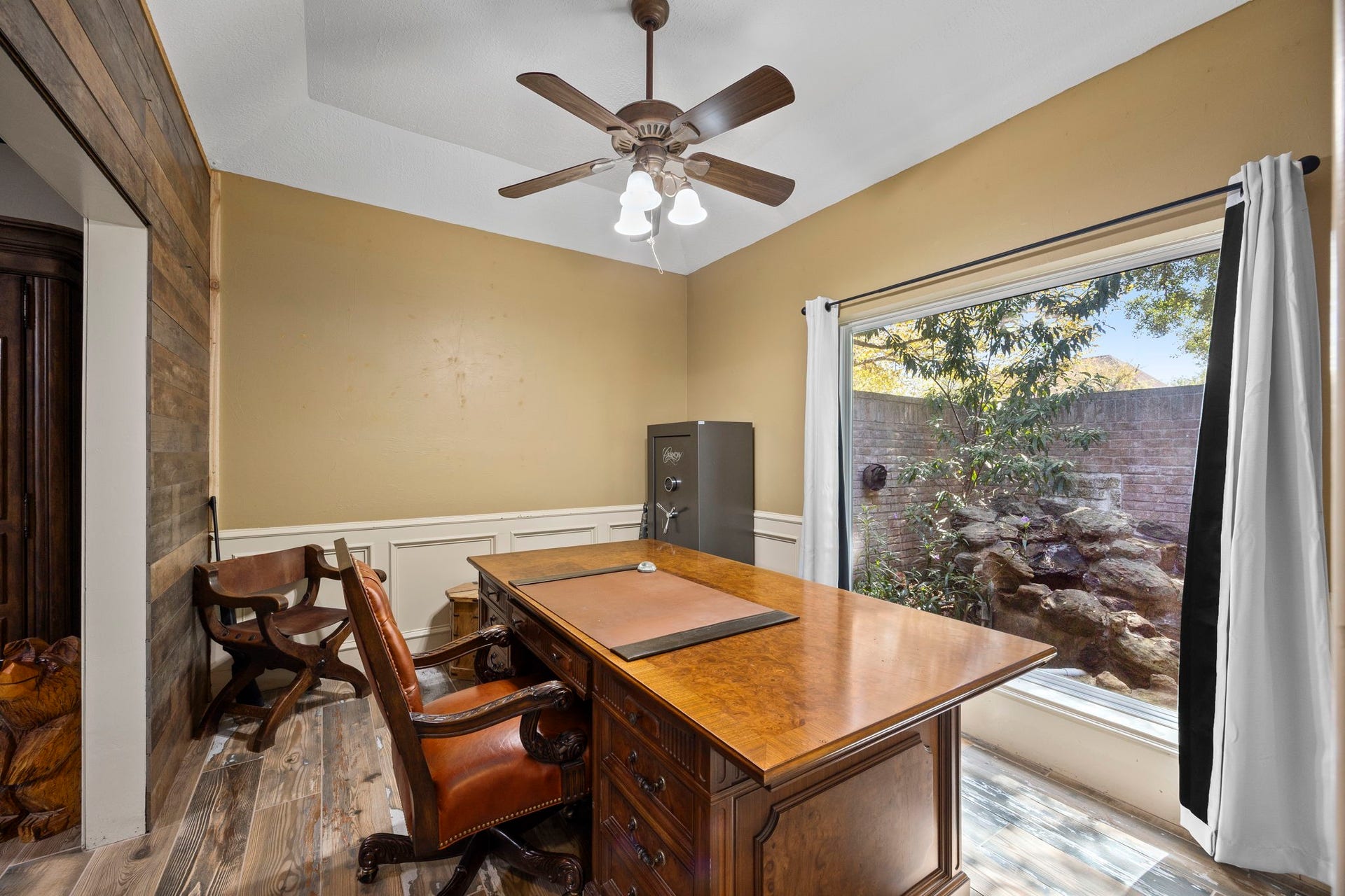 1622 Rambling Stone Drive, Richmond, TX 77406 The private study features a vaulted ceiling, wood-look flooring, and a large picture window overlooking the landscaped front courtyard. A comfortable setting for working from home while enjoying views of the outdoors.