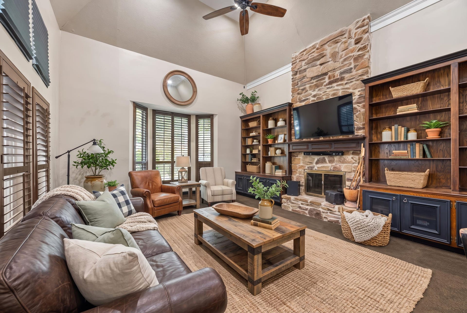 1622 Rambling Stone Drive, Richmond, TX 77406 Virtually staged to illustrate an alternative furniture arrangement, this view highlights the stone fireplace, custom built-ins with lower cabinetry, and charming bay window overlooking the front landscaping.