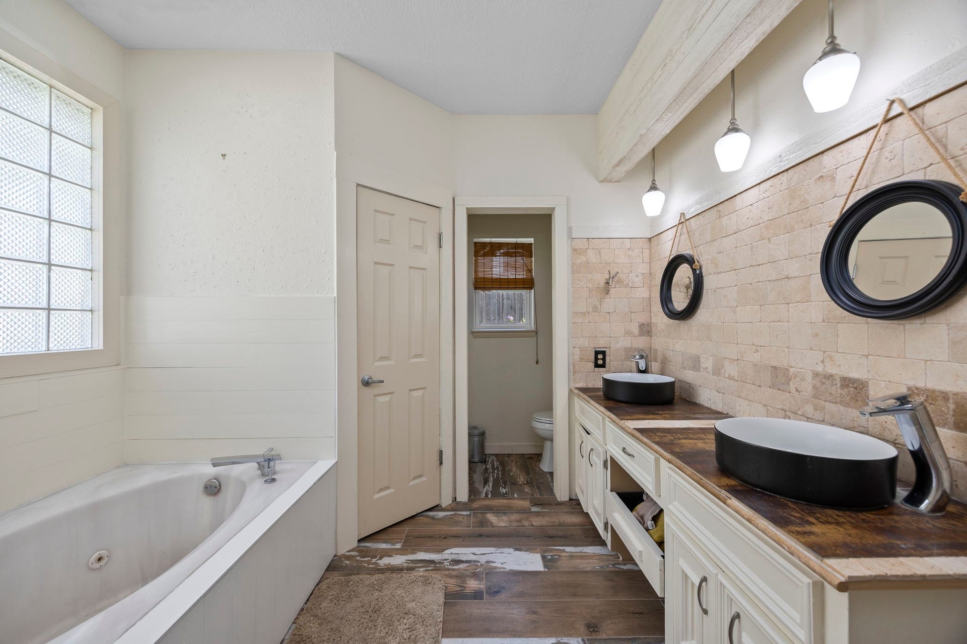 1622 Rambling Stone Drive, Richmond, TX 77406 The primary bathroom features a spacious vanity with dual above-counter vessel sinks, a full-size soaking tub, and a separate walk-in shower. Generous counter space and cabinetry provide practical storage and convenience for everyday routines.