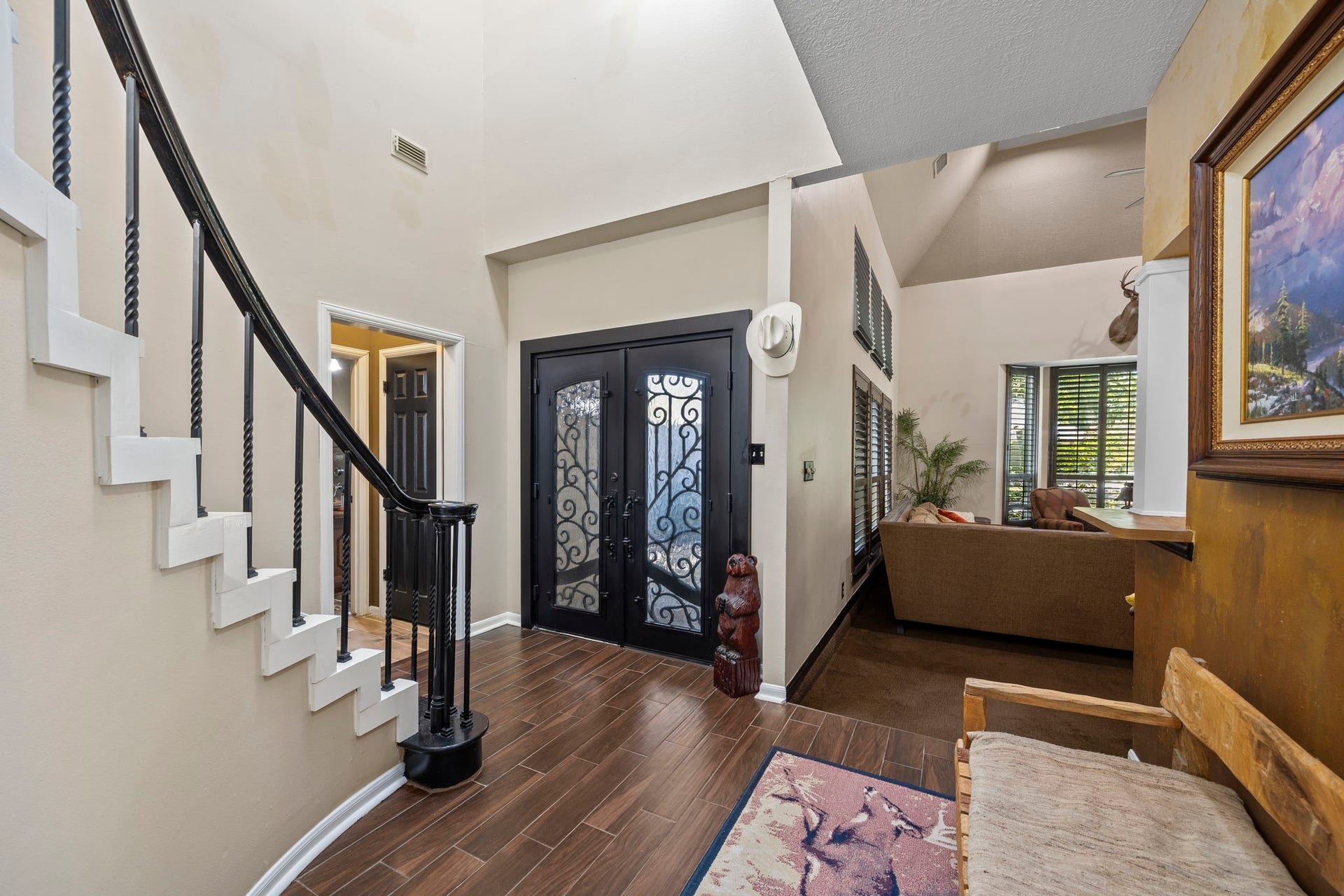 1622 Rambling Stone Drive, Richmond, TX 77406 Step inside to discover soaring ceilings, wood flooring, and a gracefully curved staircase with contrasting dark railing. The open foyer offers a glimpse into the living spaces beyond.