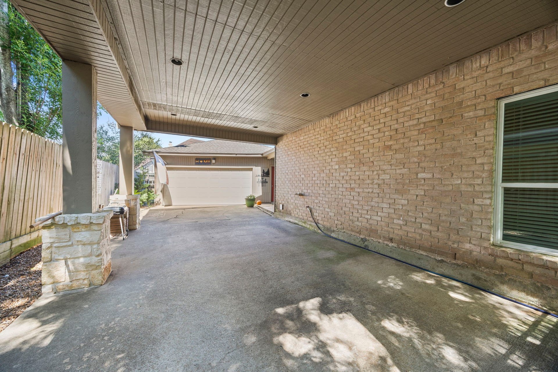 1622 Rambling Stone Drive, Richmond, TX 77406 Porte-cochere provides covered access to the home with protection from sun and rain. The extended driveway offers additional parking and plenty of space for outdoor activities and play, leading to the detached garage.