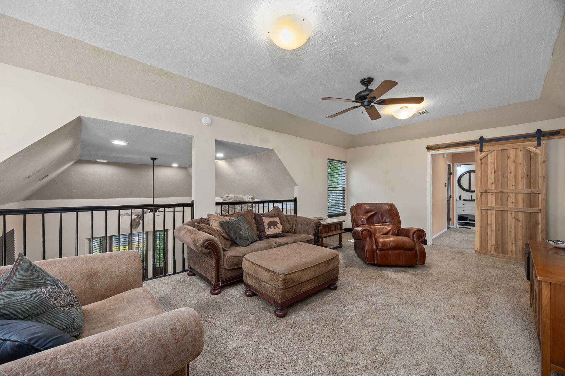 1622 Rambling Stone Drive, Richmond, TX 77406 Spacious upstairs game room overlooks the main living area below and offers plenty of room for comfortable seating, entertainment, and relaxation. A sliding barn door leads to an adjoining room.
