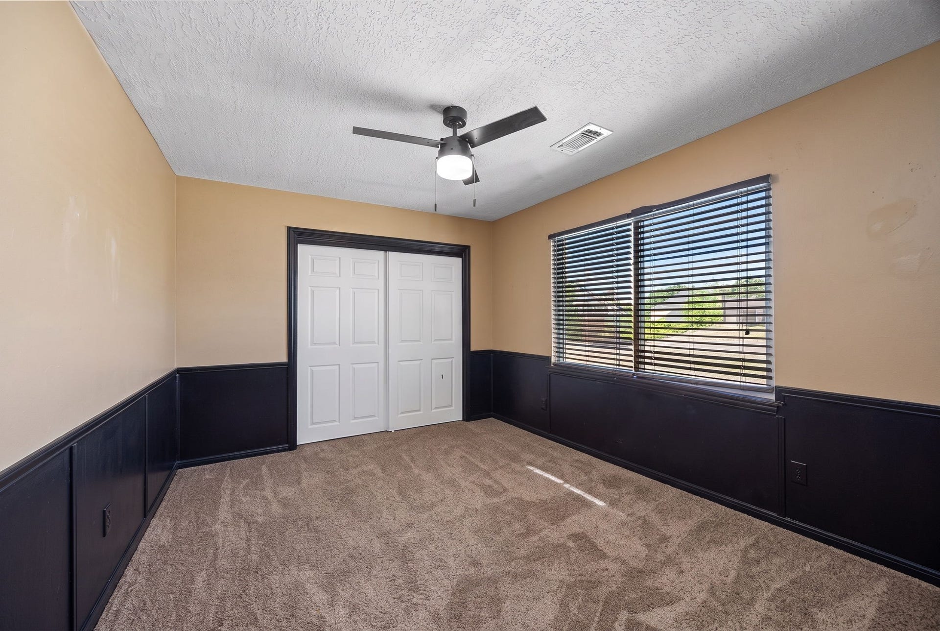 1622 Rambling Stone Drive, Richmond, TX 77406 Another upstairs bedroom offers generous floor space, a ceiling fan, double-door closet, and contrasting dark wainscoting that adds character to the room.
