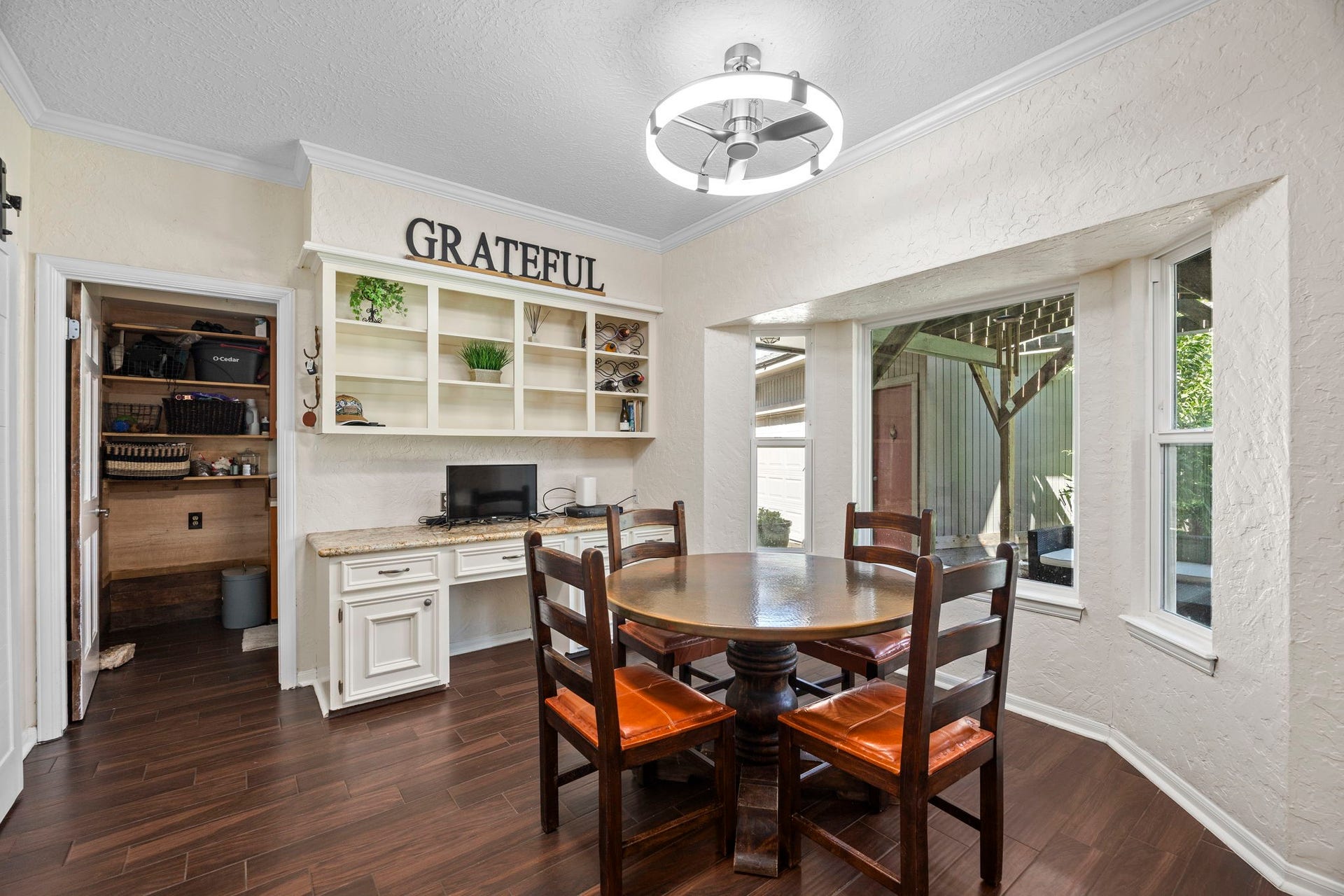 1622 Rambling Stone Drive, Richmond, TX 77406 Another view of the breakfast room highlights the built-in desk and shelving, offering convenient space for organization, cookbooks, or a household workstation. Direct access to the laundry room adds everyday functionality to this area of the home.