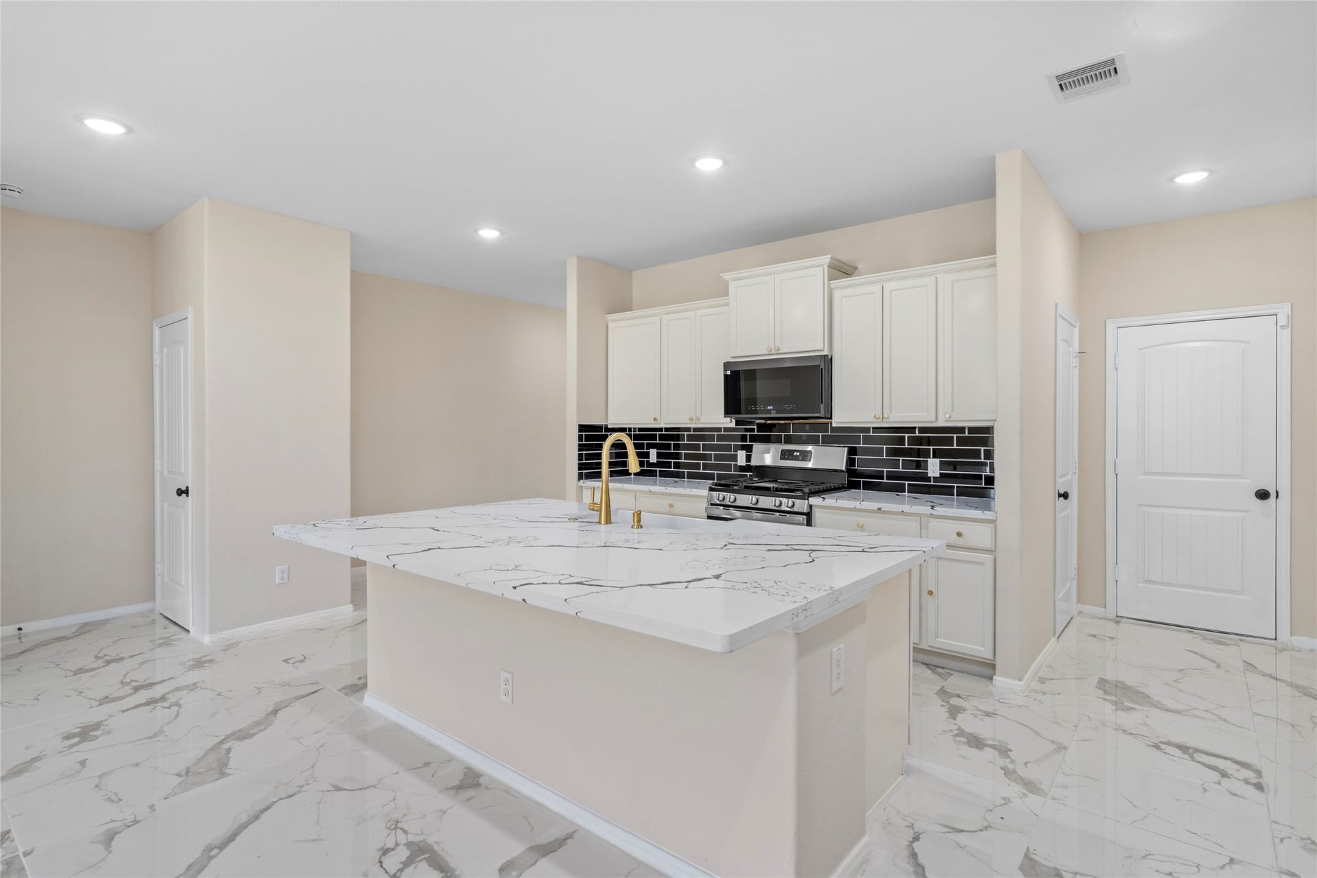 9423 Mineral Rock Lane, Richmond, TX 77407 Discover culinary luxury in this stunning kitchen, featuring sleek marble countertops, modern appliances, and a stylish tile backsplash, all set on elegant tile flooring.