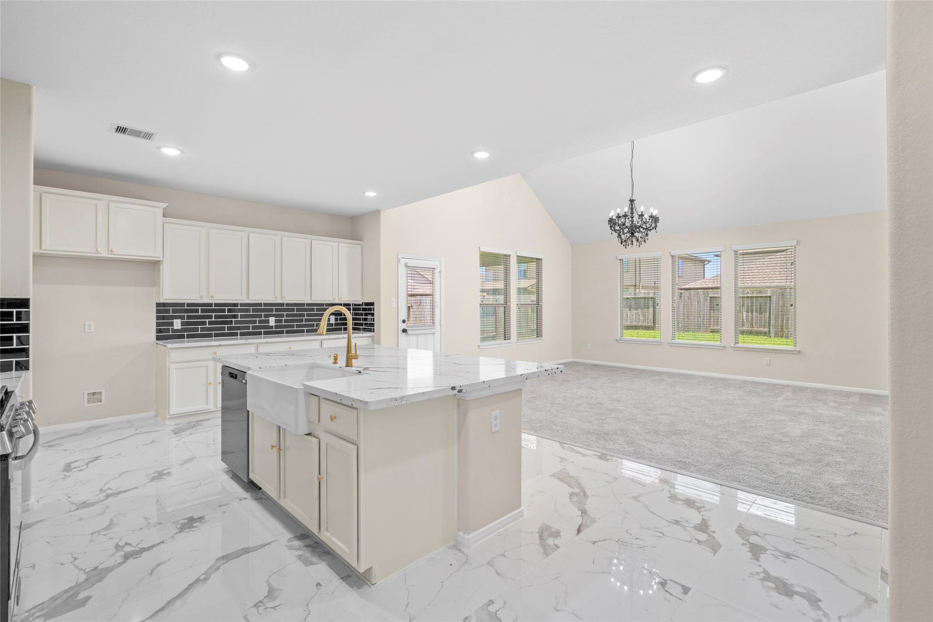 9423 Mineral Rock Lane, Richmond, TX 77407 Experience seamless living in this elegant kitchen and living room combo, featuring a stunning tile floor, sleek cabinetry, and abundant natural light for the perfect blend of style and comfort.