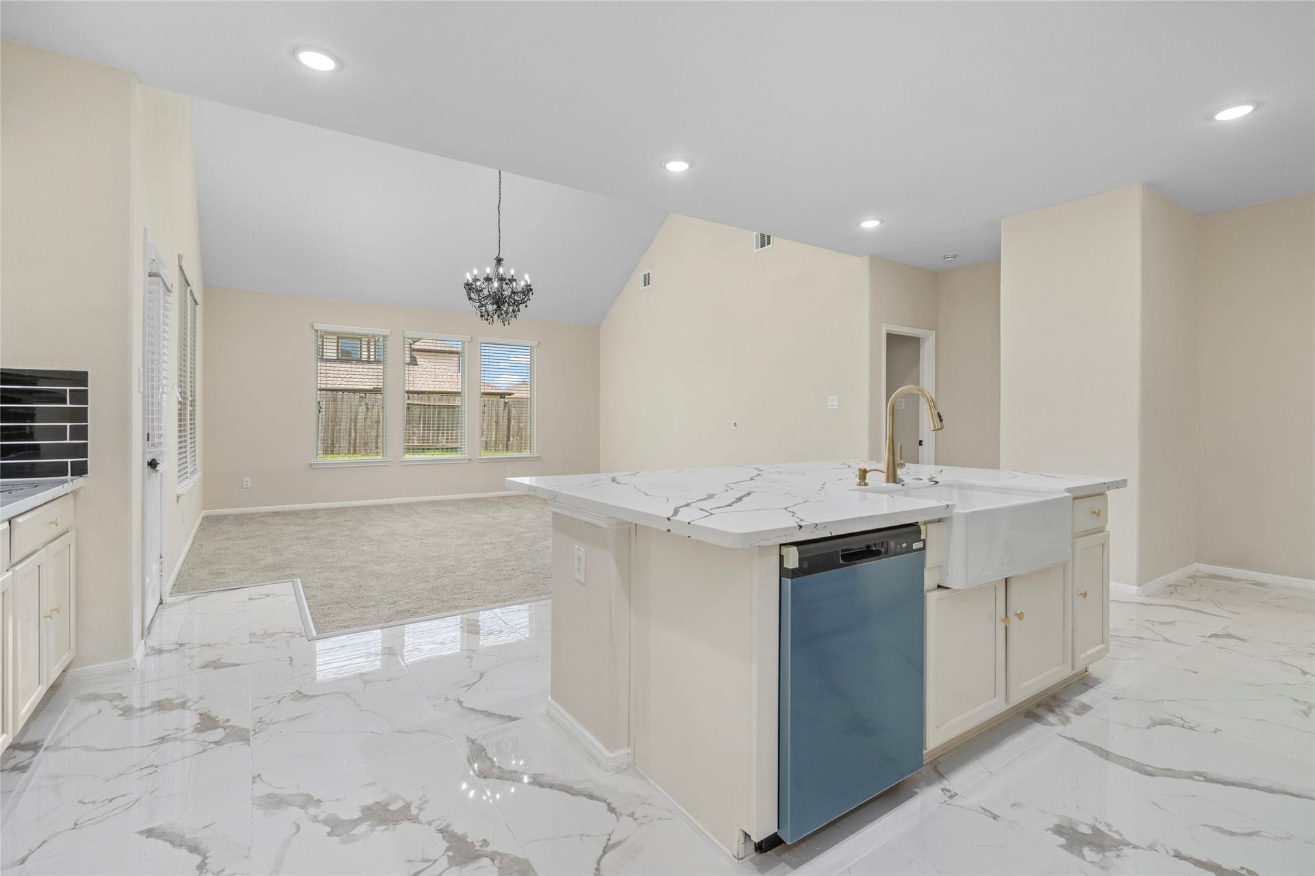9423 Mineral Rock Lane, Richmond, TX 77407 Experience culinary elegance in this stunning kitchen, featuring sleek marble countertops, a spacious island, and modern fixtures, seamlessly flowing into an open living area filled with natural light.