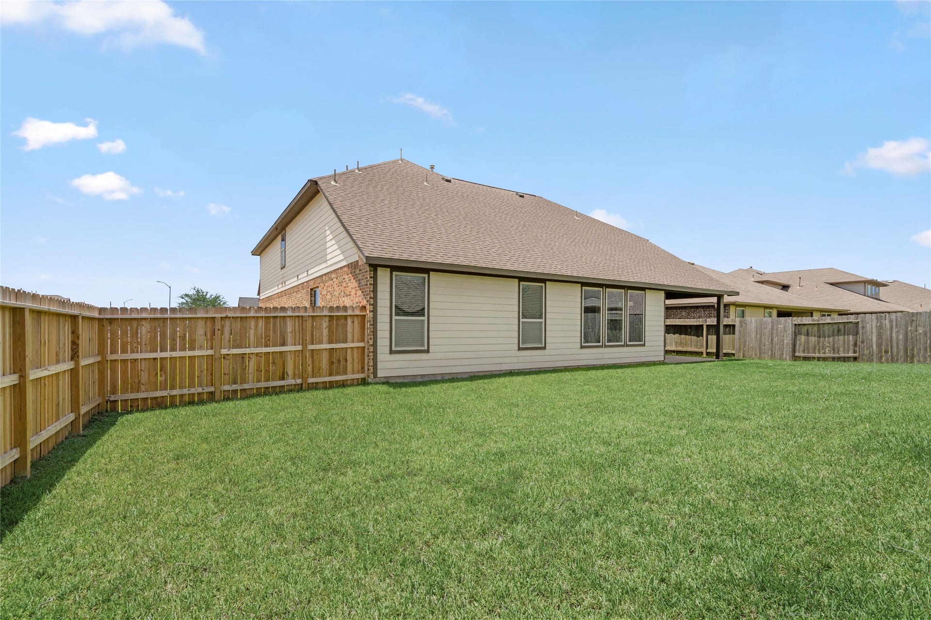 9423 Mineral Rock Lane, Richmond, TX 77407 Discover a spacious backyard oasis perfect for relaxation and outdoor activities, enclosed by a classic wooden fence for privacy and charm.