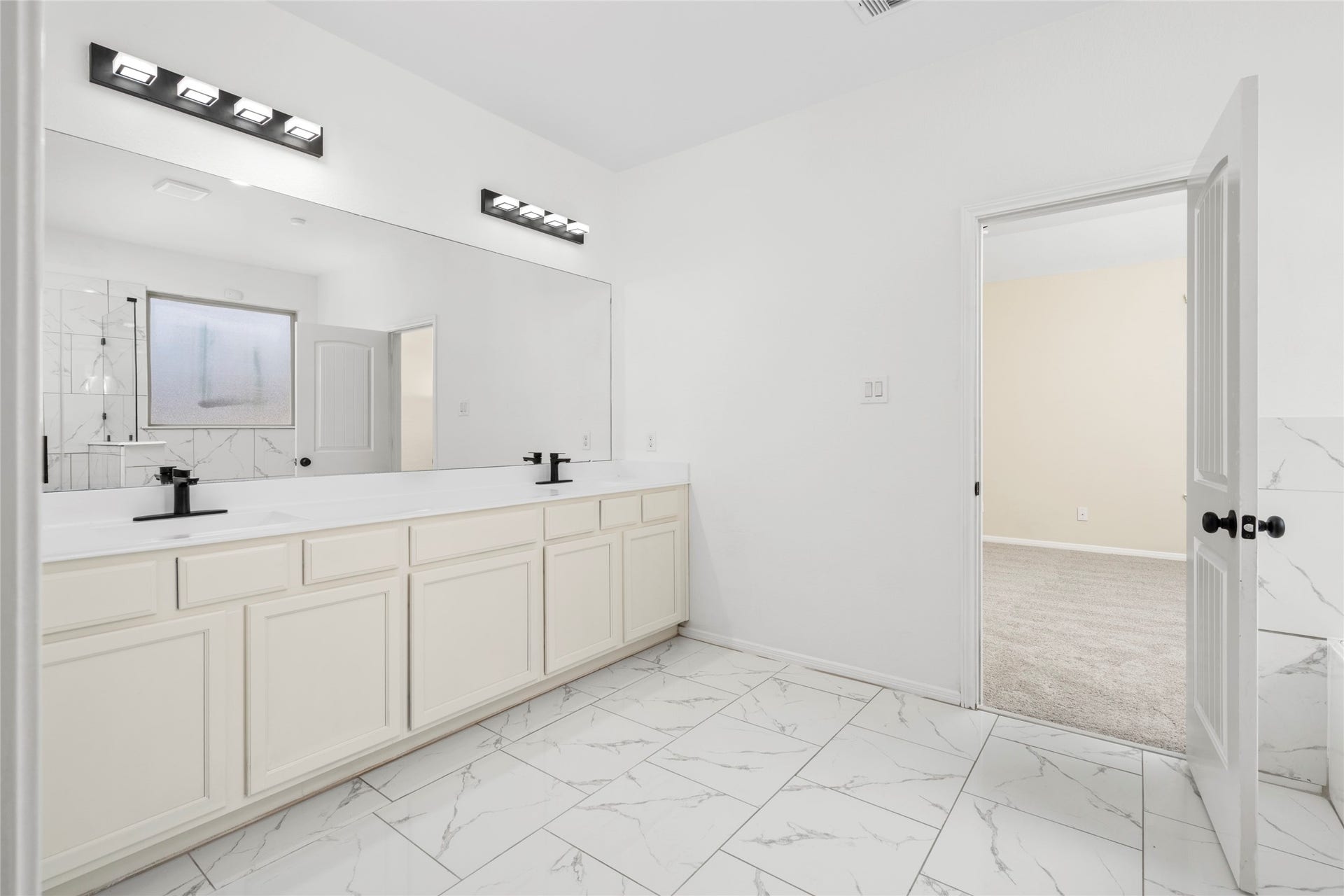 9423 Mineral Rock Lane, Richmond, TX 77407 Experience luxury and convenience in this spacious primary bathroom featuring elegant double sinks and sleek, modern finishes.