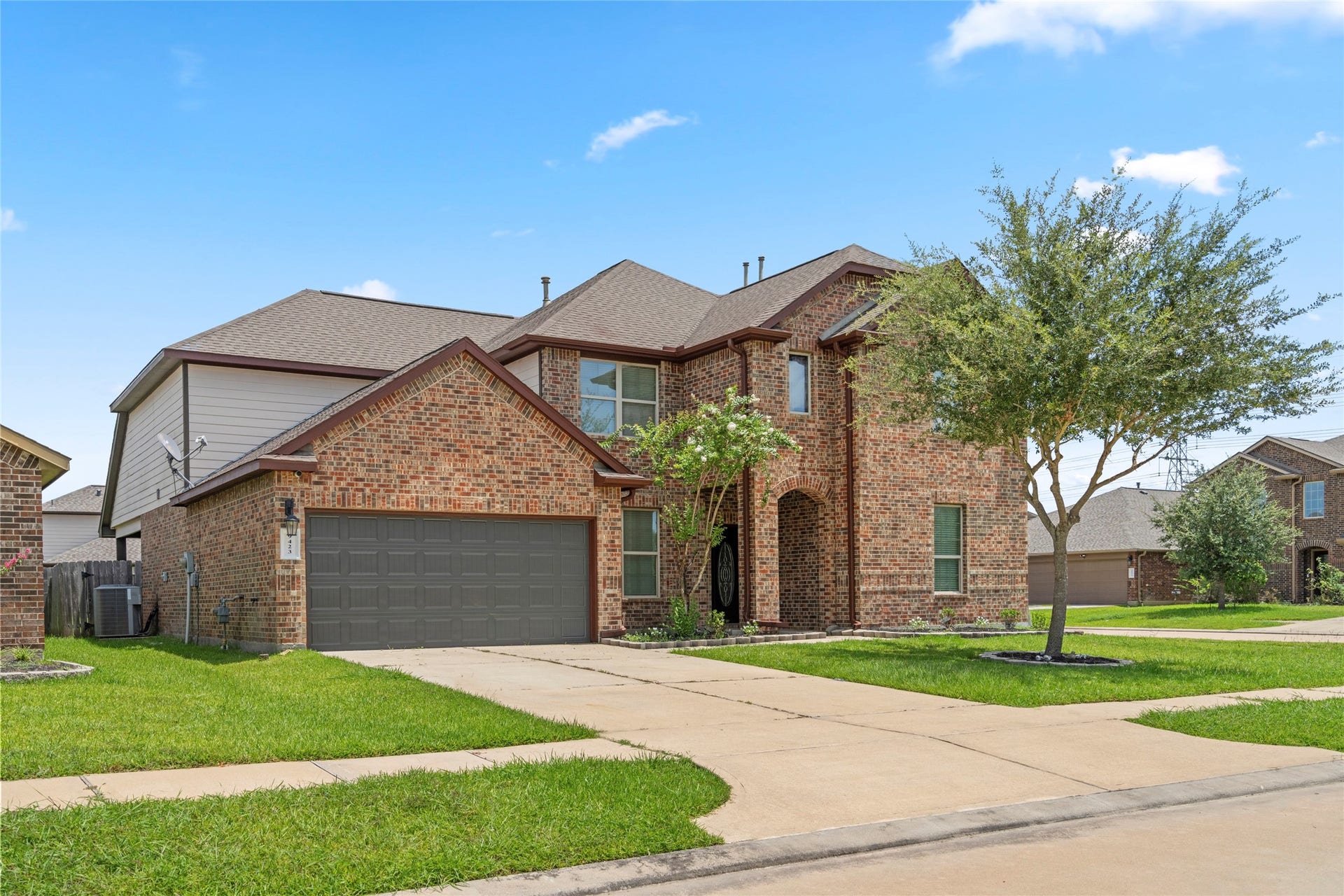 9423 Mineral Rock Lane, Richmond, TX 77407 Two-story brick exterior with an oversized two-car garage and a manicured front lawn set in a quiet, established neighborhood.
