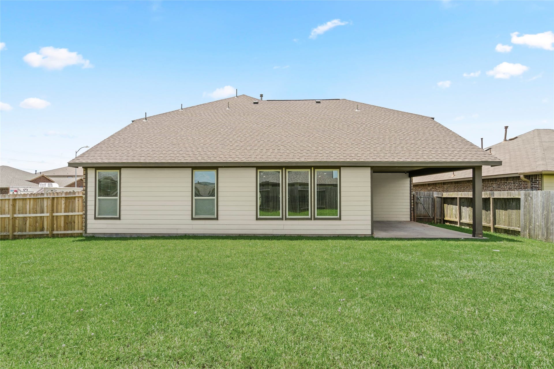 9423 Mineral Rock Lane, Richmond, TX 77407 Expansive backyard with lush green lawn and a covered patio perfect for outdoor gatherings.