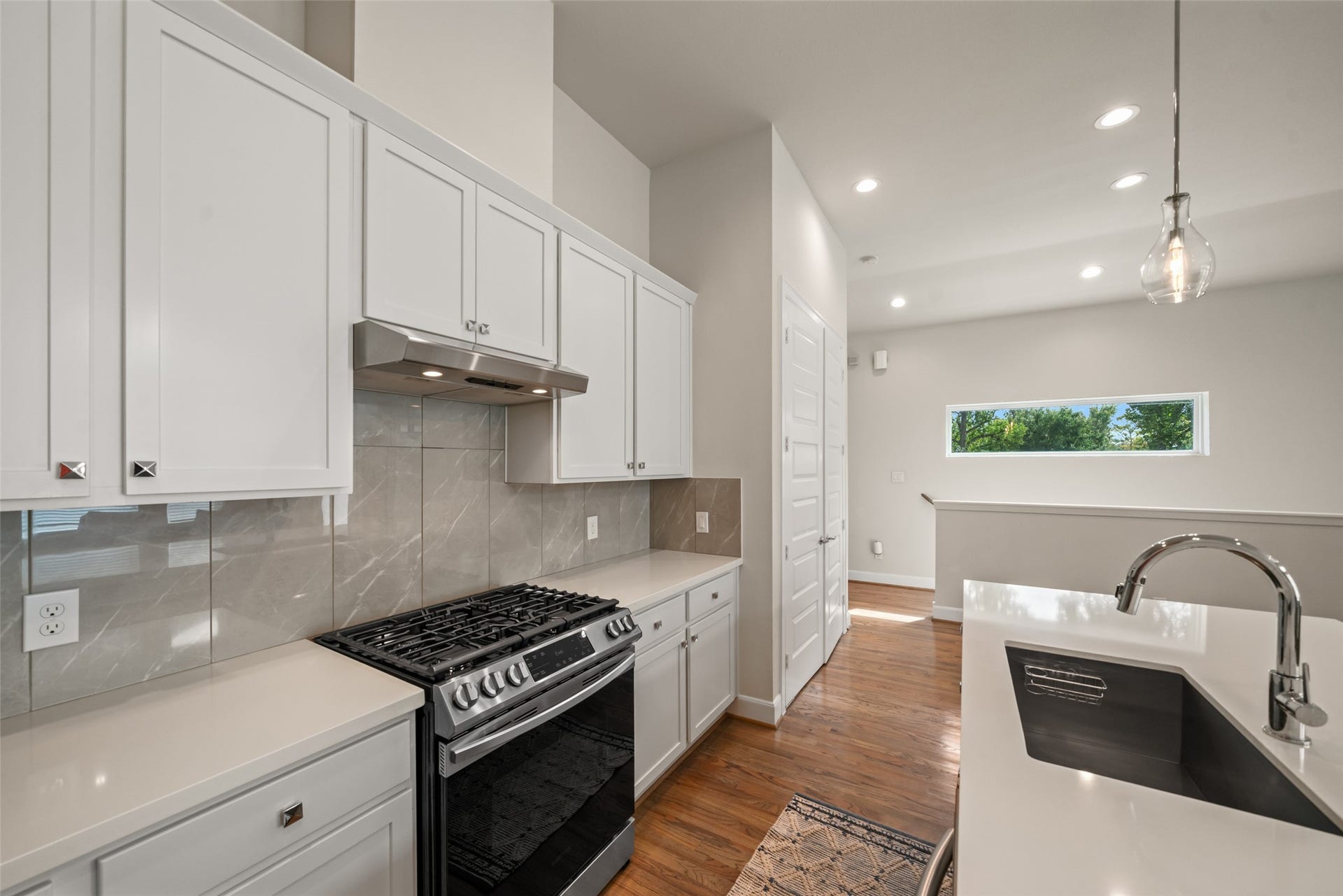 502 W Donovan Street, #A, Houston, TX 77091 Pendant lights over the island and a clerestory window by the dining area.