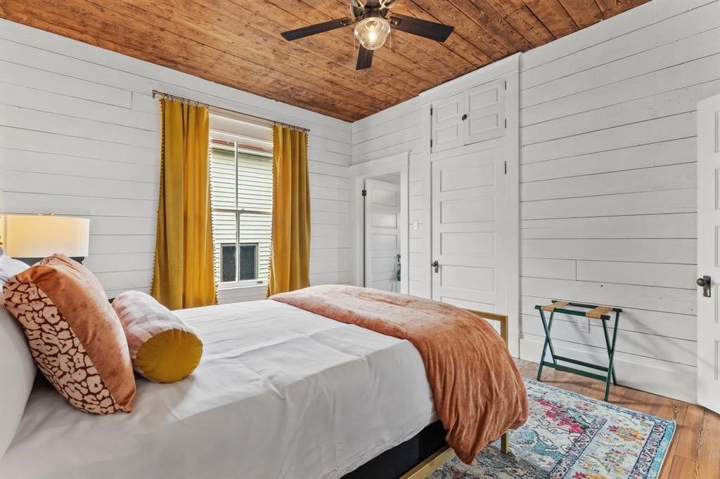 801 24th Street, Galveston, TX 77550 Bedroom three on the second floor. Hardwood floors, stained ceiling and updated ceiling fan. Large window letting in natural light.
