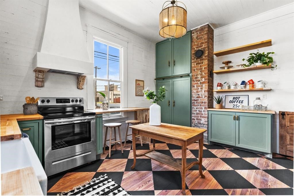 801 24th Street, Galveston, TX 77550 Beautifully updated kitchen featuring updated vent hood, butchers block countertops, painted hardwood floors and tons of storage!