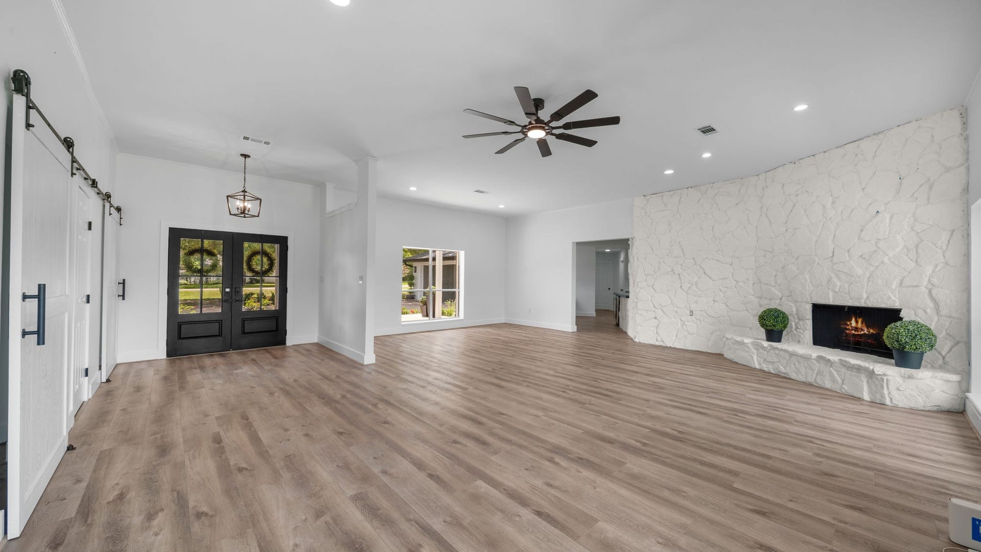 15502 Kitty Hawk Drive, Waller, TX 77484 Entry, dining and Family Room. This is a very large open space, If an office is needed, the custom plans do show where an office can go. Just ask to view. Barn doors take you into the hallway to 2 bedrooms, other one takes you into hall of the Primary Retreat