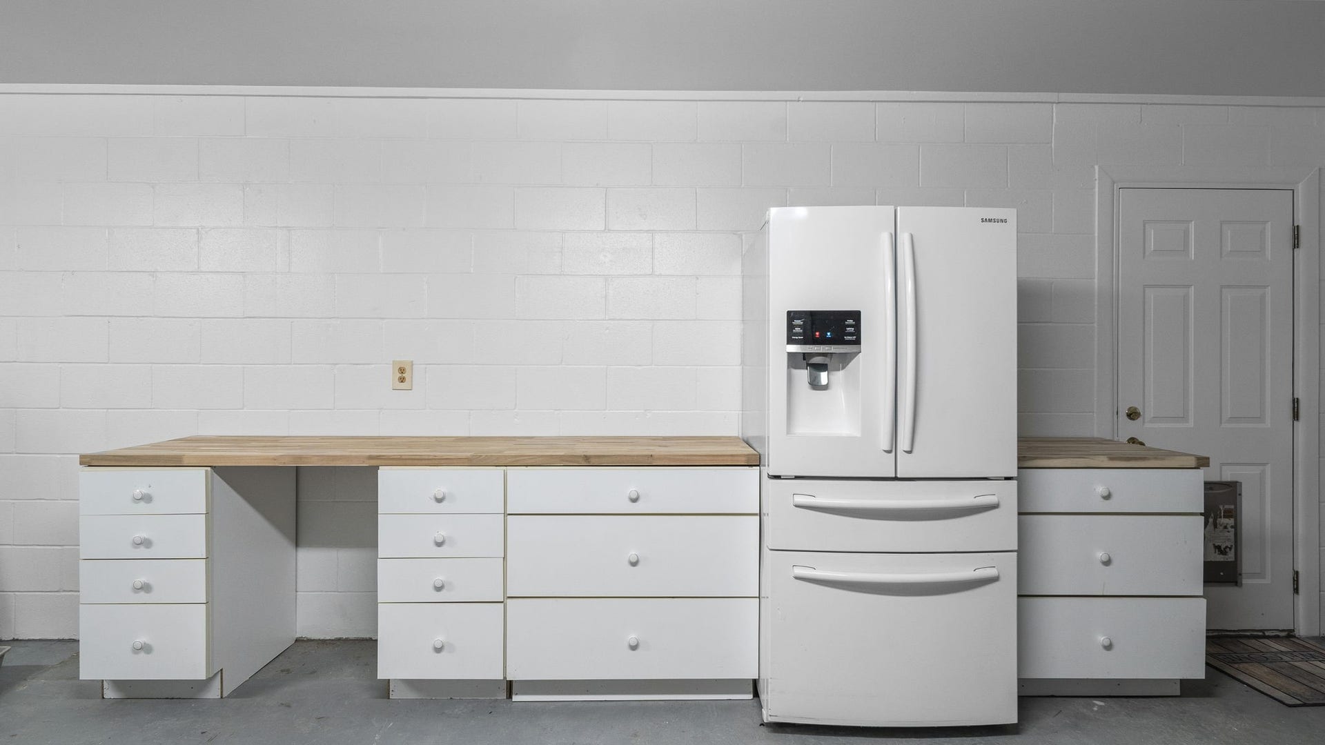 15502 Kitty Hawk Drive, Waller, TX 77484 3 car garage with work space. Work bench and storage with Refrigerator