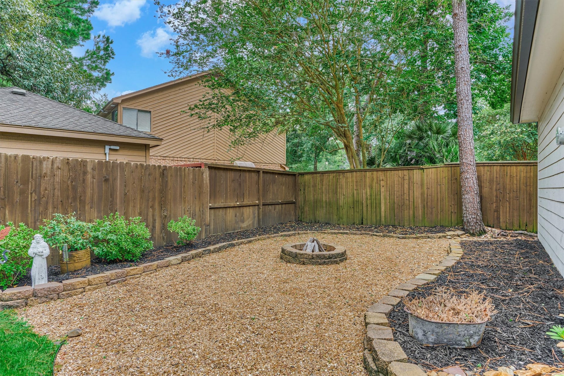 42 Golden Shadow Circle, The Woodlands, TX 77381 With abundant space for gardening, relaxing, or gathering around the fire pit, this backyard is designed for every lifestyle.