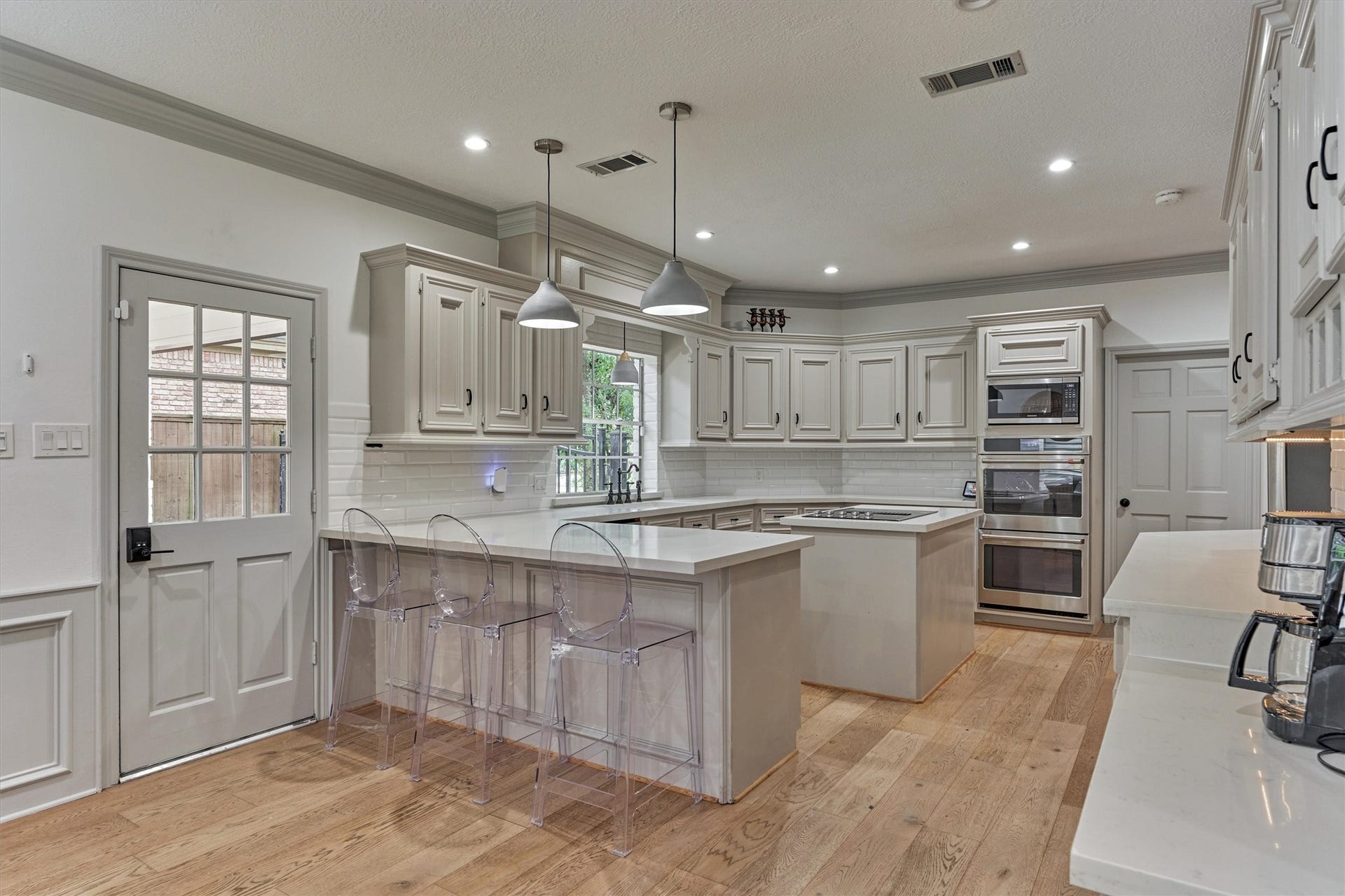 42 Golden Shadow Circle, The Woodlands, TX 77381 Beautifully updated kitchen featuring stainless steel appliances, including double ovens, and an island with electric cooktop.