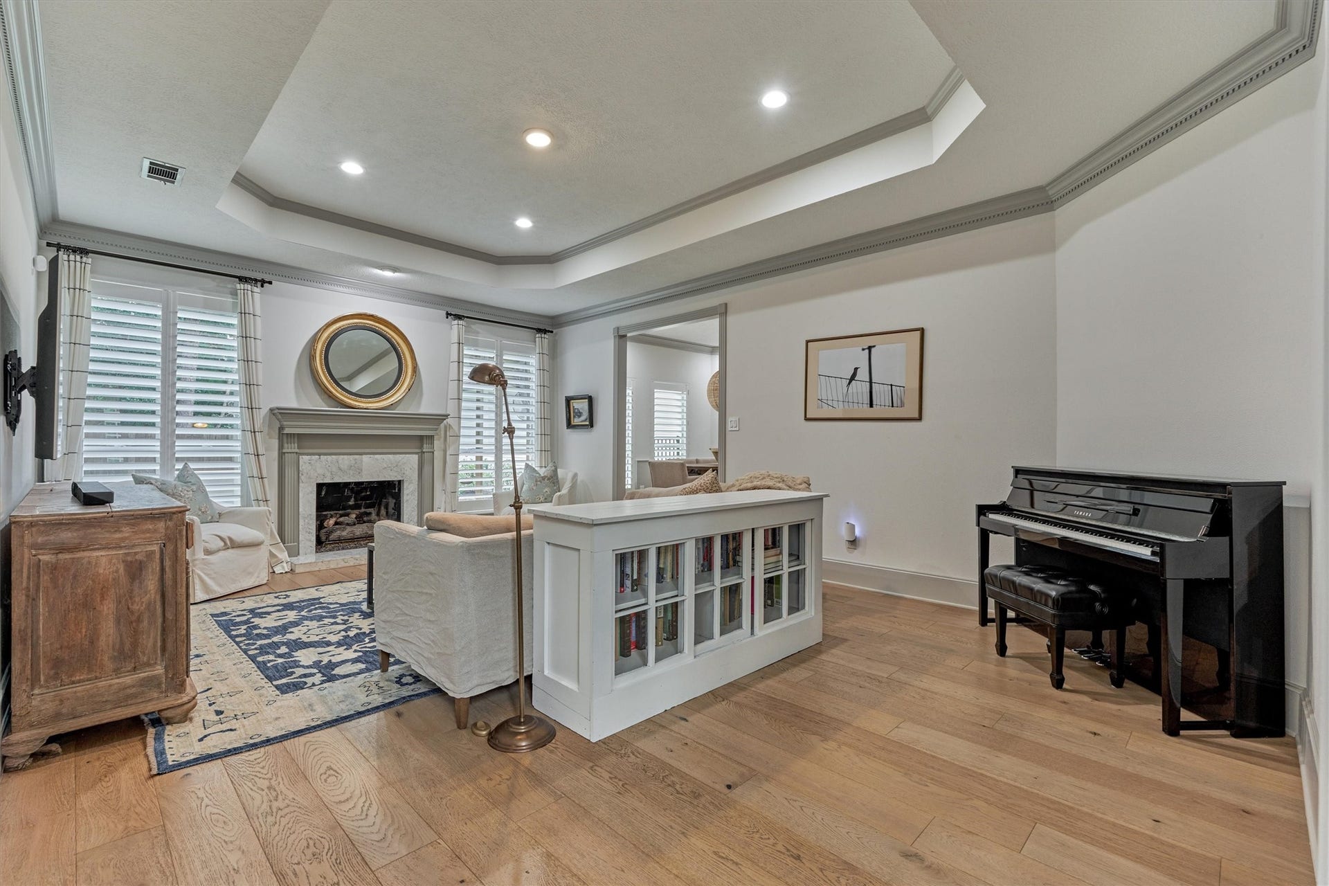 42 Golden Shadow Circle, The Woodlands, TX 77381 A spacious den with a cozy fireplace exudes warmth, elegance, and everyday comfort.