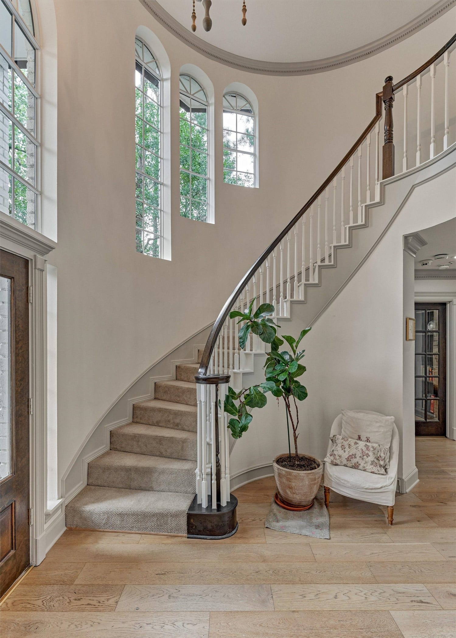 42 Golden Shadow Circle, The Woodlands, TX 77381 A dramatic two-story foyer features a sweeping staircase leading to the second-floor living areas, complemented by timeless architectural details.