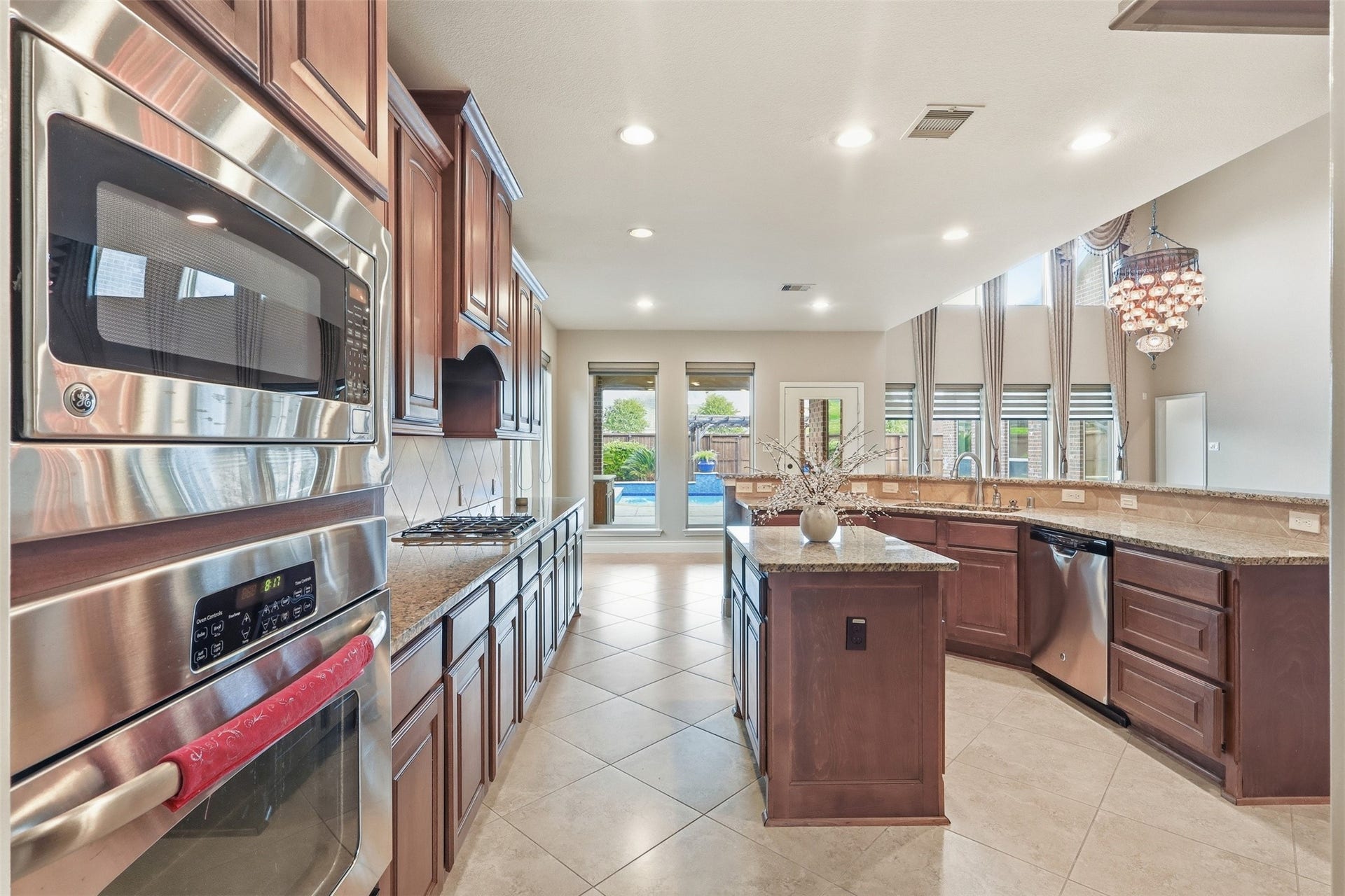 4130 Clover Ridge Lane, Sugar Land, TX 77479 There's a large island for prep and seating, and the room is filled with natural light from the large windows. A chandelier adds a touch of elegance, and the open layout flows into a bright living area.