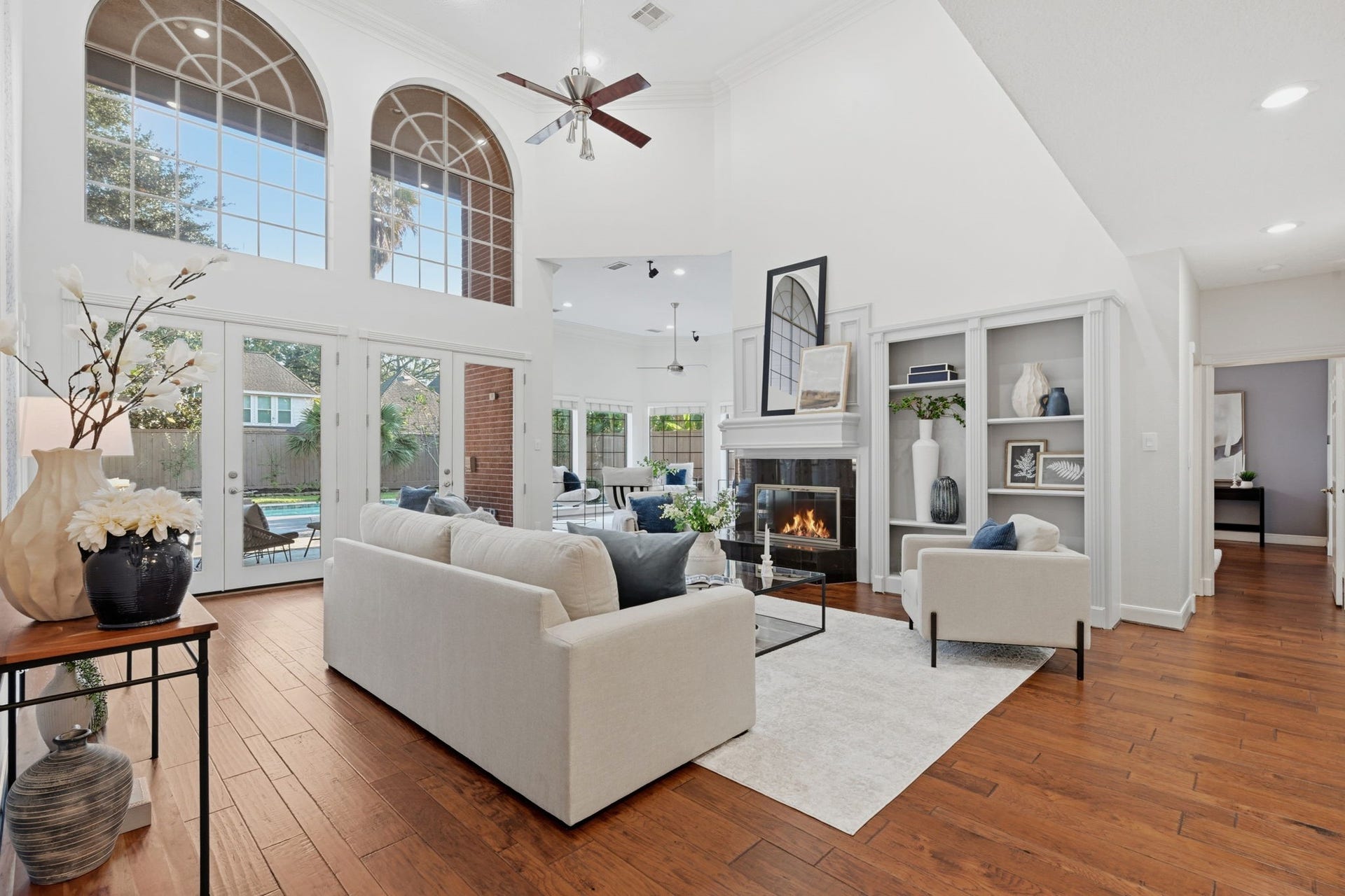 Prepare to be impressed by this spectacular family room featuring dramatic soaring ceilings & a magnificent wall of windows overlooking the backyard retreat. The expansive two-story design allows natural light to cascade throughout the room, enhancing its open, sophisticated appeal.