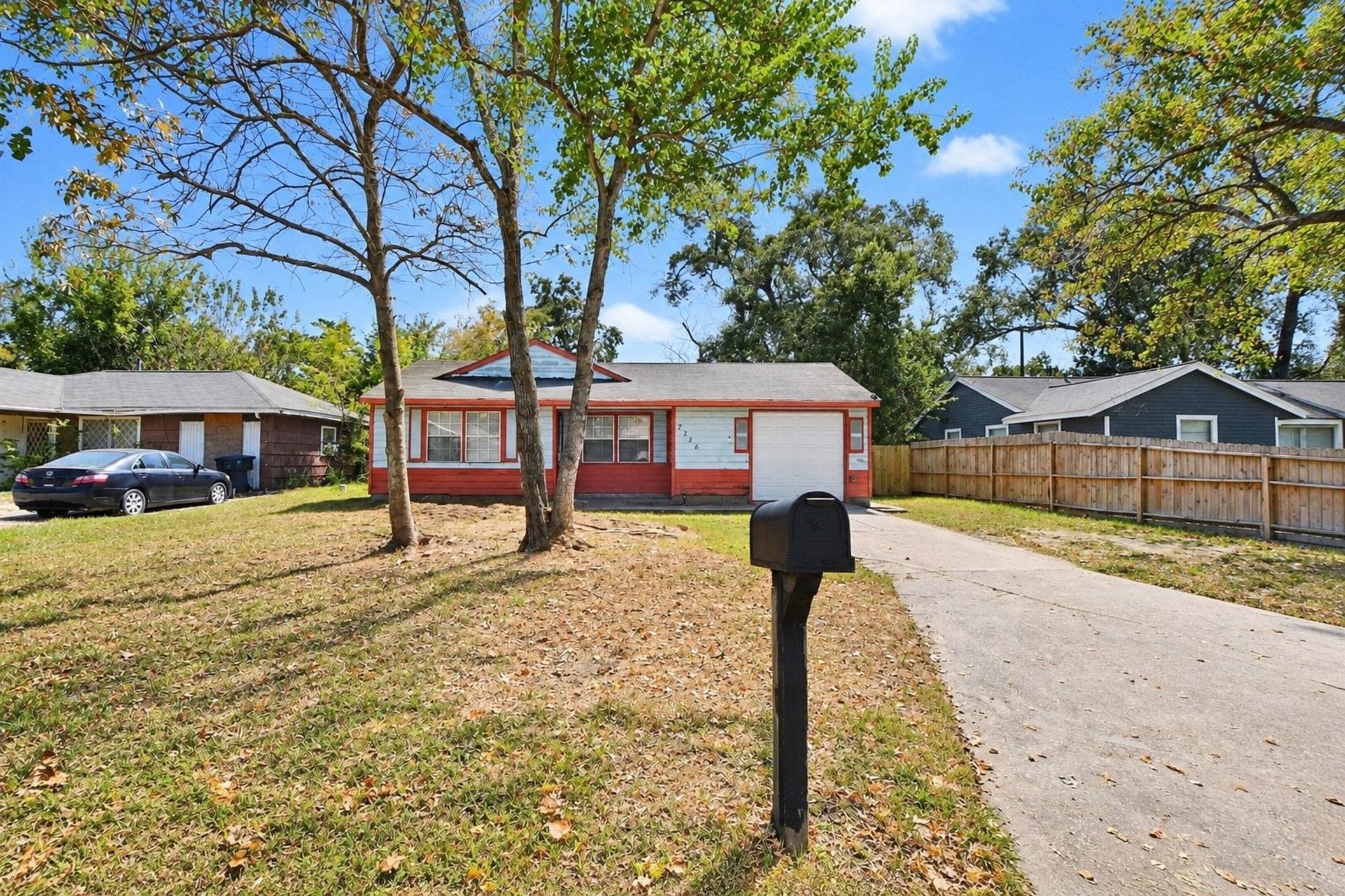 Spacious front yard, a private driveway, an attached garage, and mature trees that add charm and shade to the property.