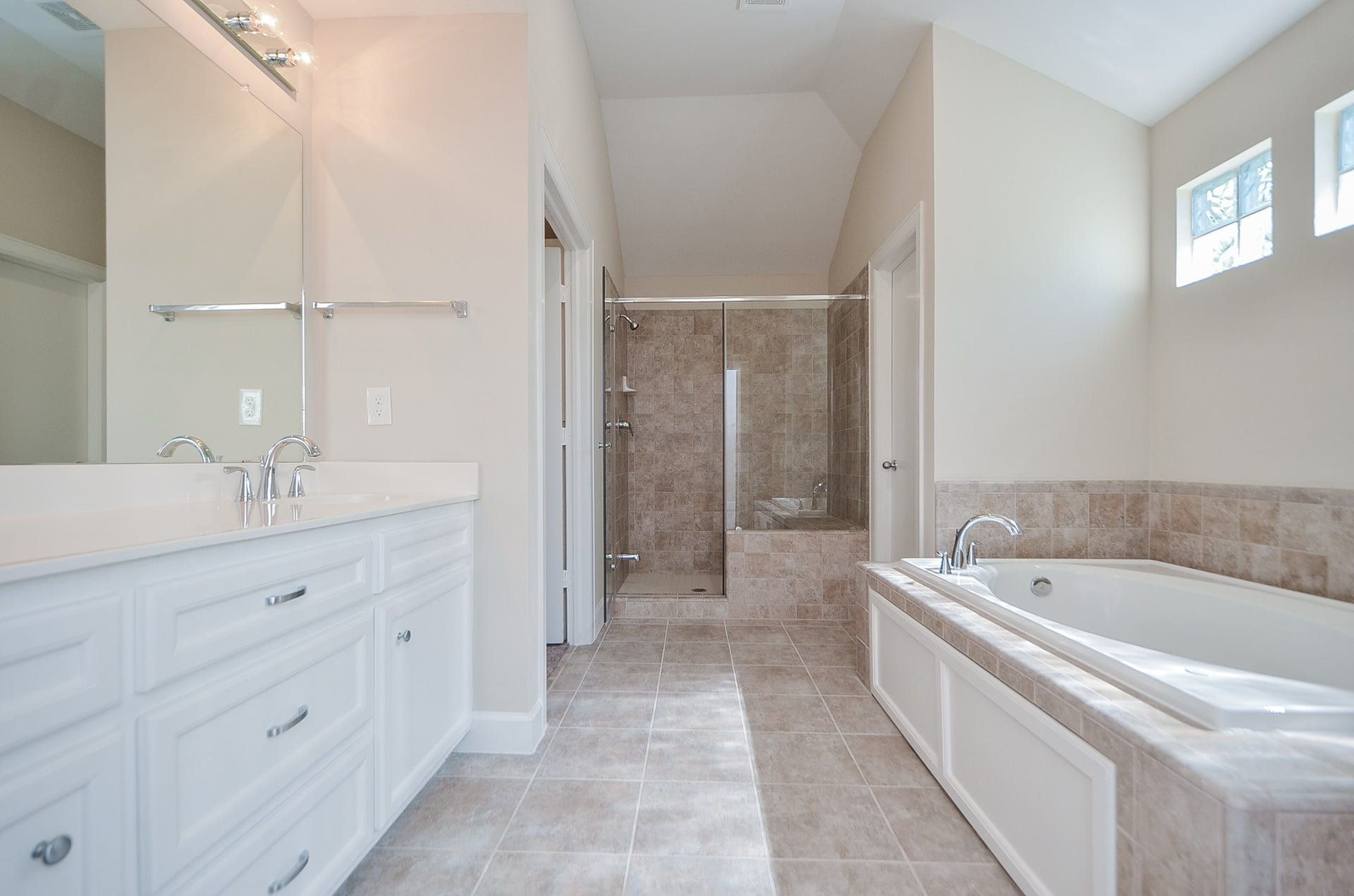 924 E 39th Street, Houston, TX 77022 Tile flooring, an oversized walk in shower, dual sinks, pull out drawers, white cabinets, and a massive jetted tub are some of the features you will enjoy in the master bathroom.