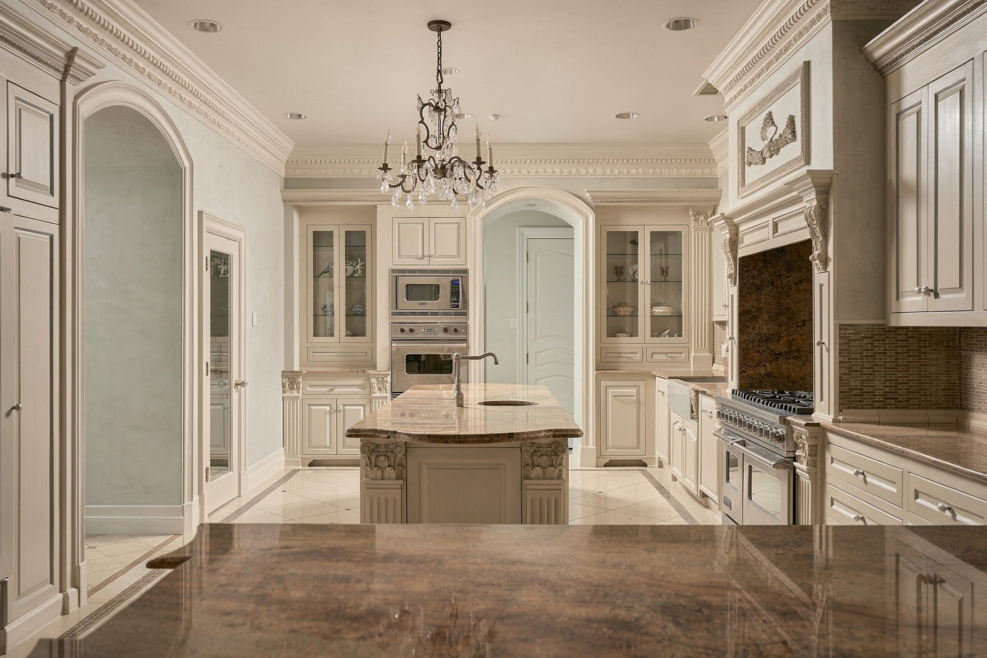 2115 River Oaks Boulevard, Houston, TX 77019 A reverse view of the kitchen highlights the central island, glass-front cabinetry and the decorative detailing carried throughout the space.