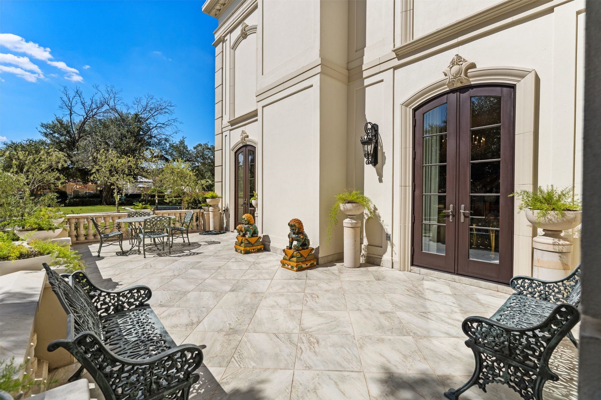2115 River Oaks Boulevard, Houston, TX 77019 A paved patio along the residence offers a quiet setting for outdoor seating, bordered by lawn, planted beds and mature trees.