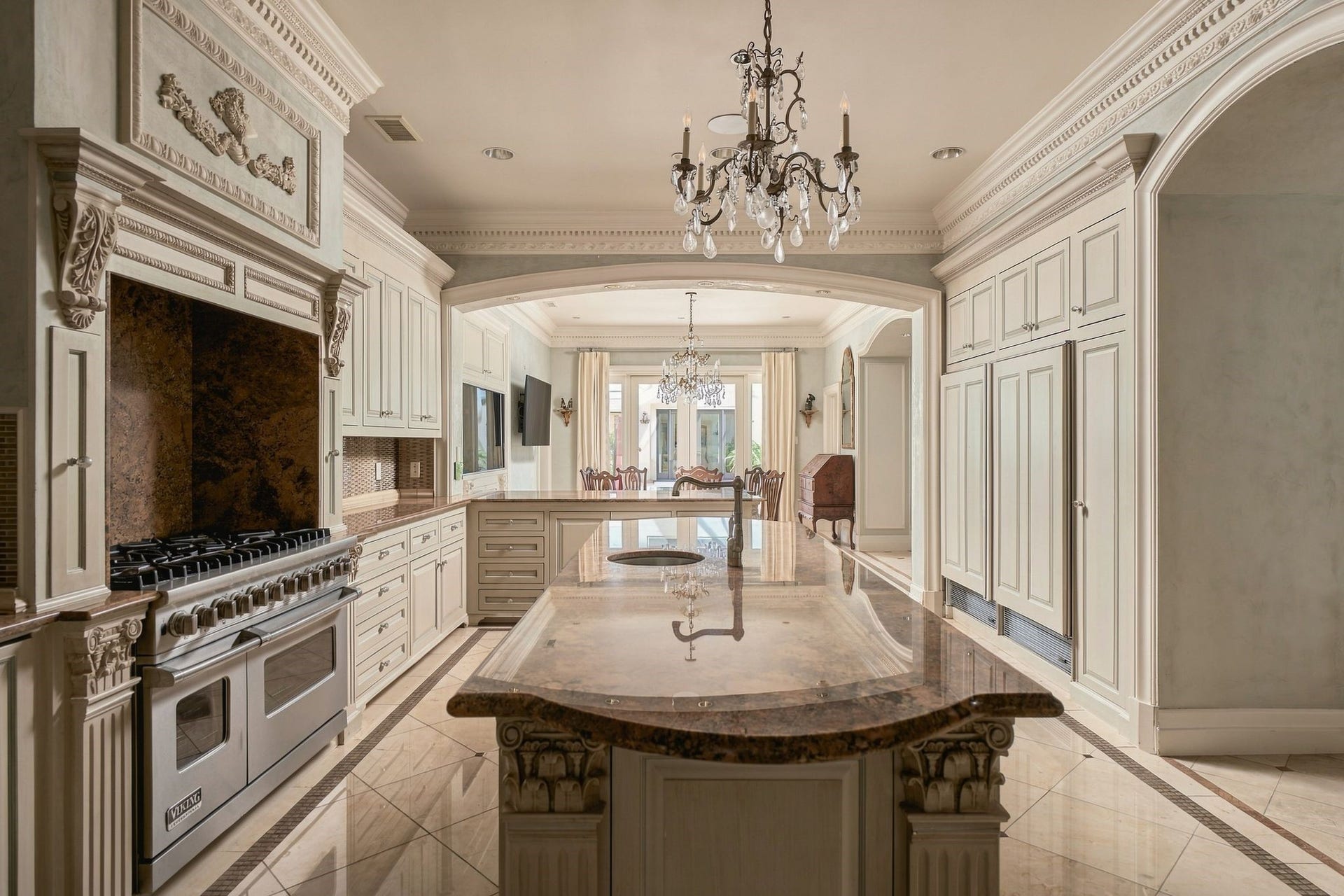 2115 River Oaks Boulevard, Houston, TX 77019 Marble kitchen island with pool atrium view. Kitchen complemented by high end appliances and custom cabinetry.