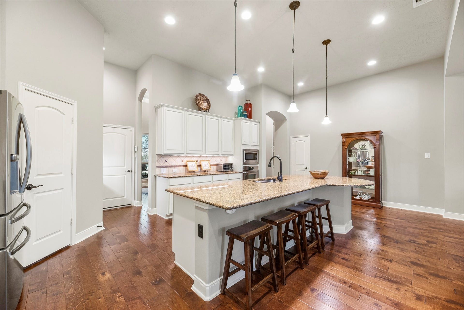 8623 Crescent Spur Drive, Richmond, TX 77406 The oversized island with seating and pendant lighting is the natural gathering spot for morning coffee, homework and holiday prep.