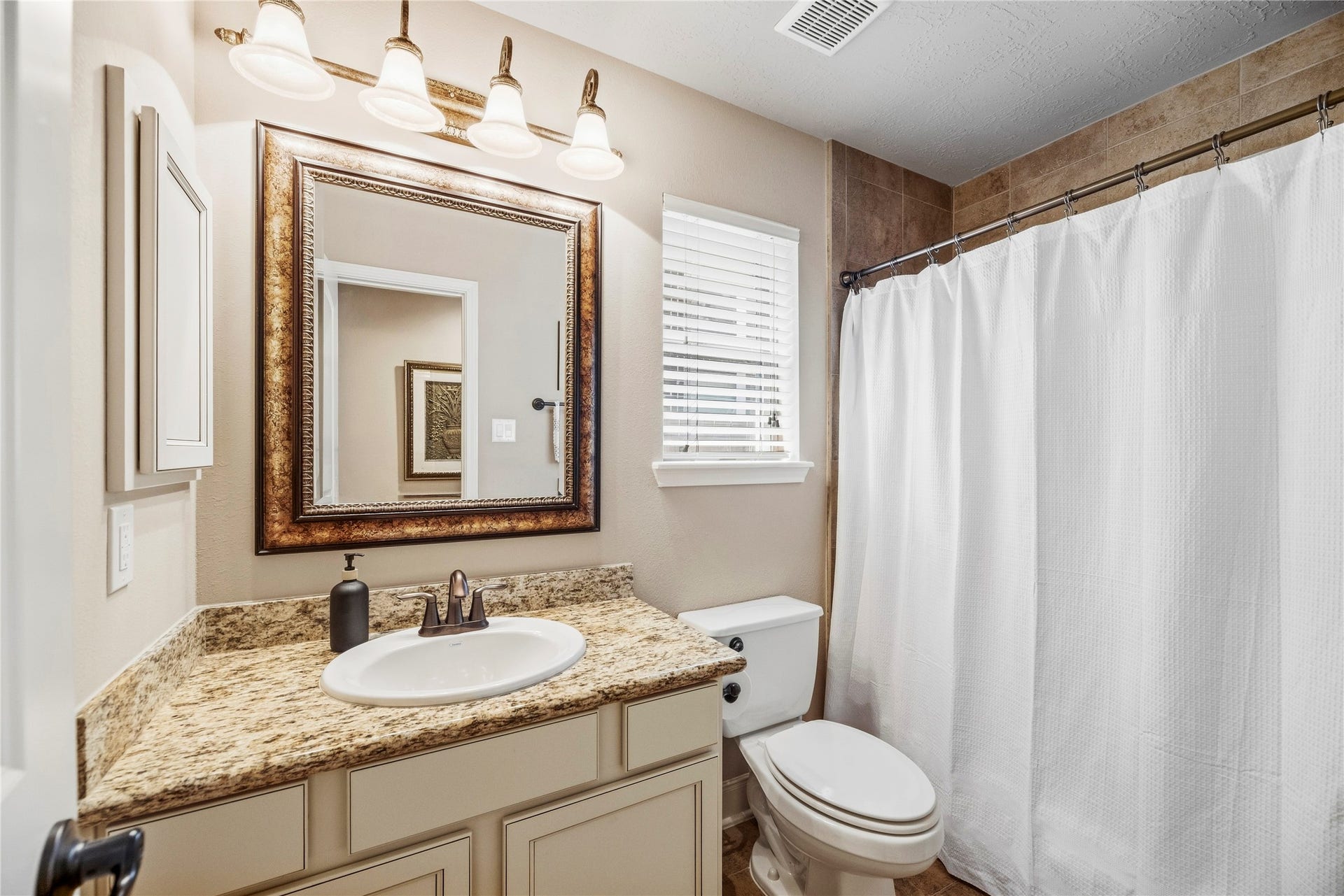 8623 Crescent Spur Drive, Richmond, TX 77406 The secondary bath is well appointed with a framed mirror, vanity and tub and shower combination.